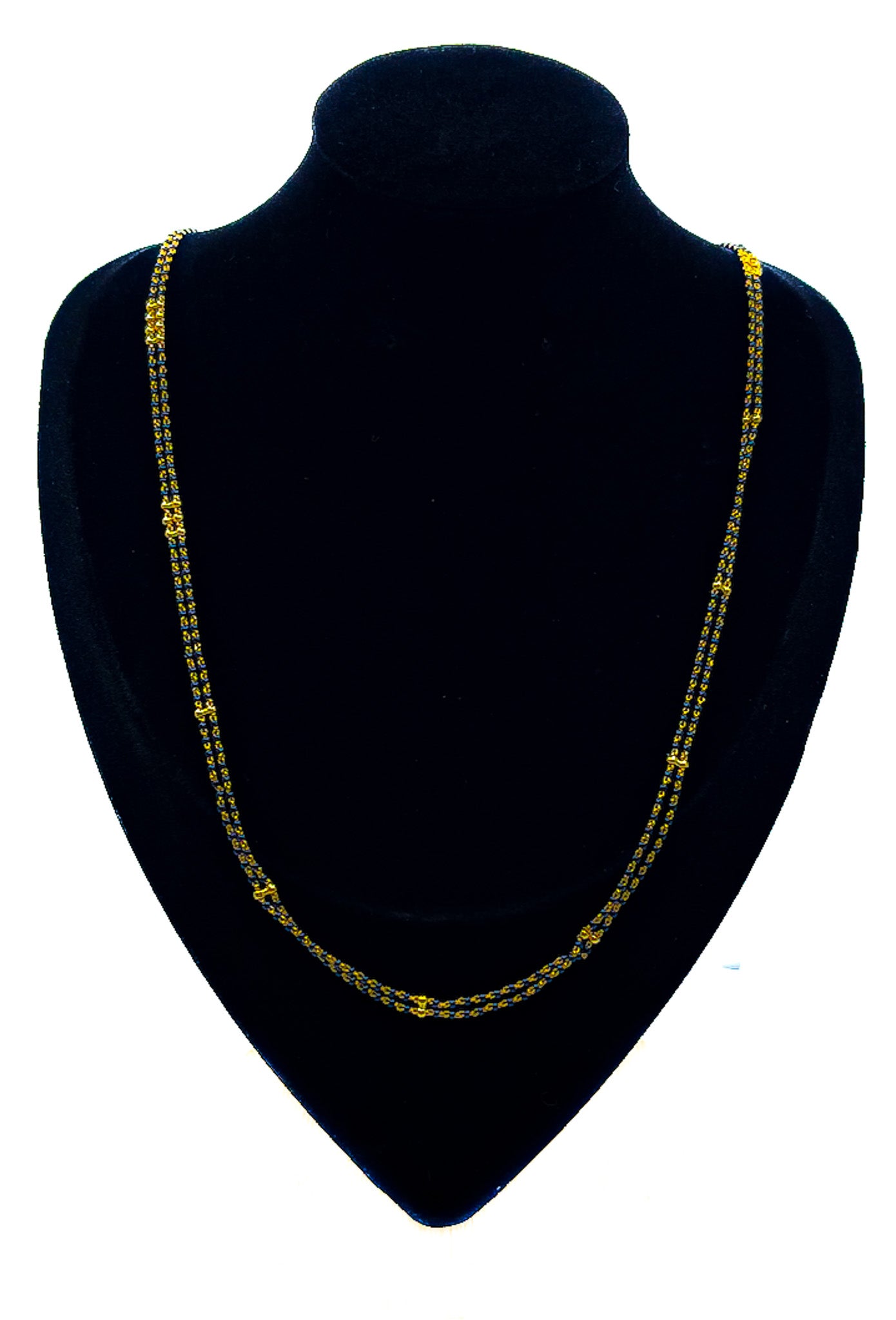 22K gold beaded necklace with blue beads displayed on a black velvet bust