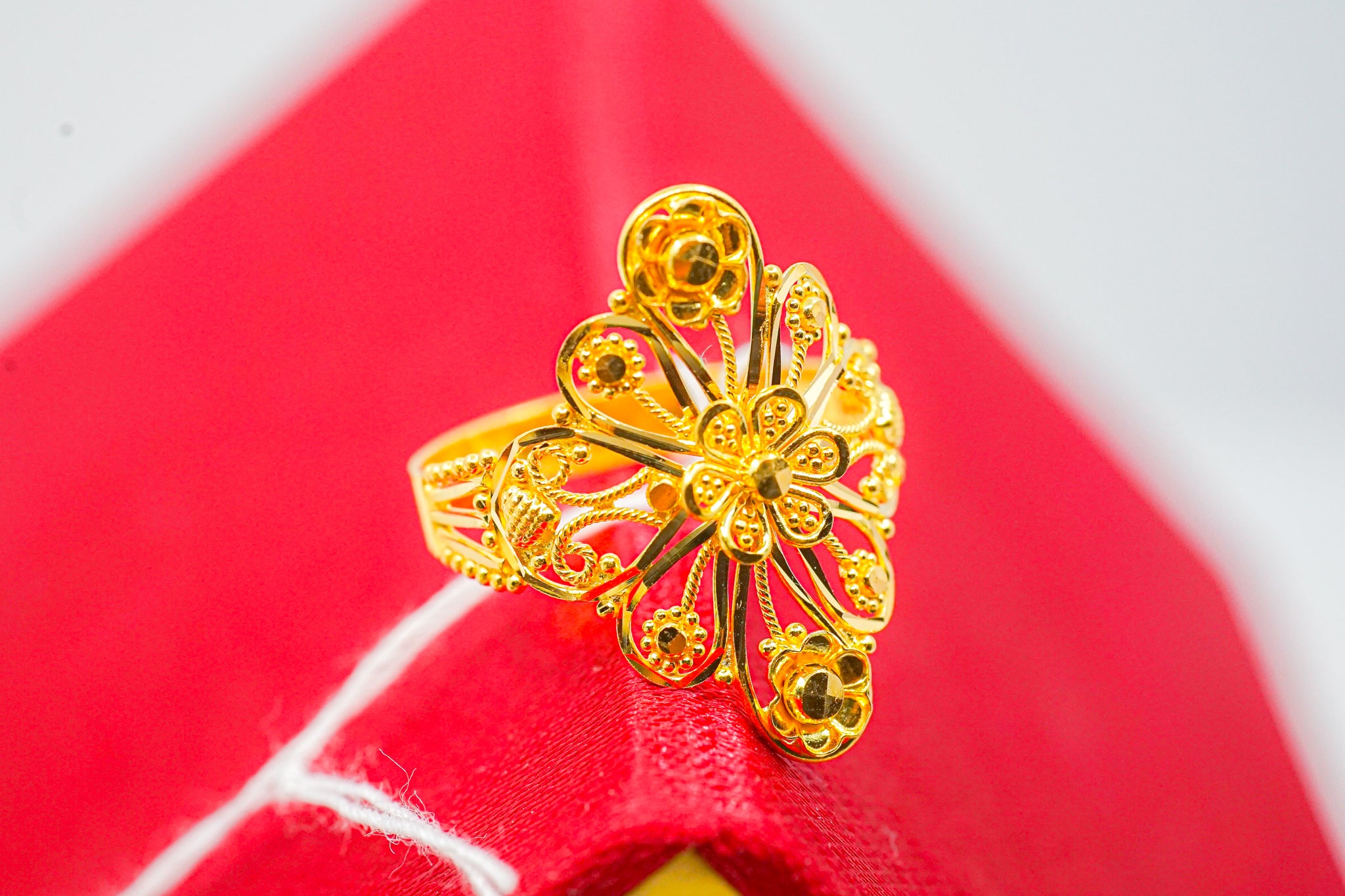 22K gold floral filigree statement ring (4.14g) on red background