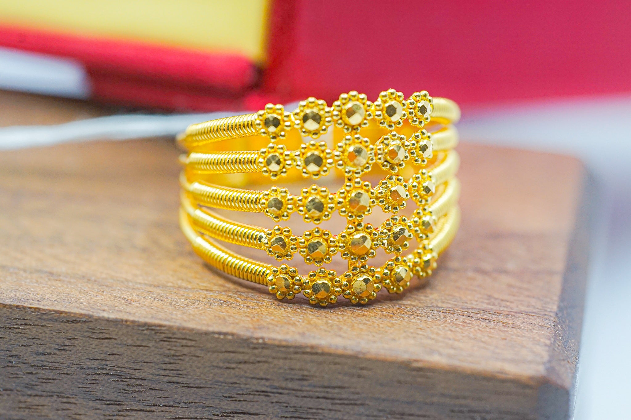 22K gold floral wide band ring (7.44g) on wooden display