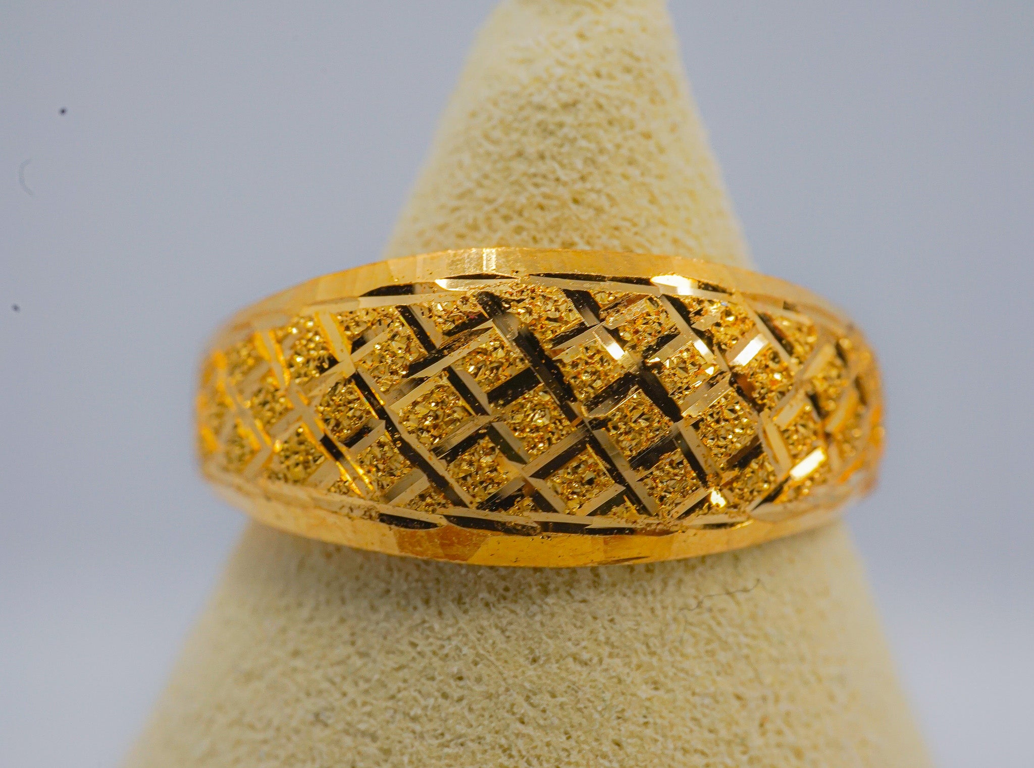 22K gold textured band ring with lattice pattern, size 8, shown on ring display