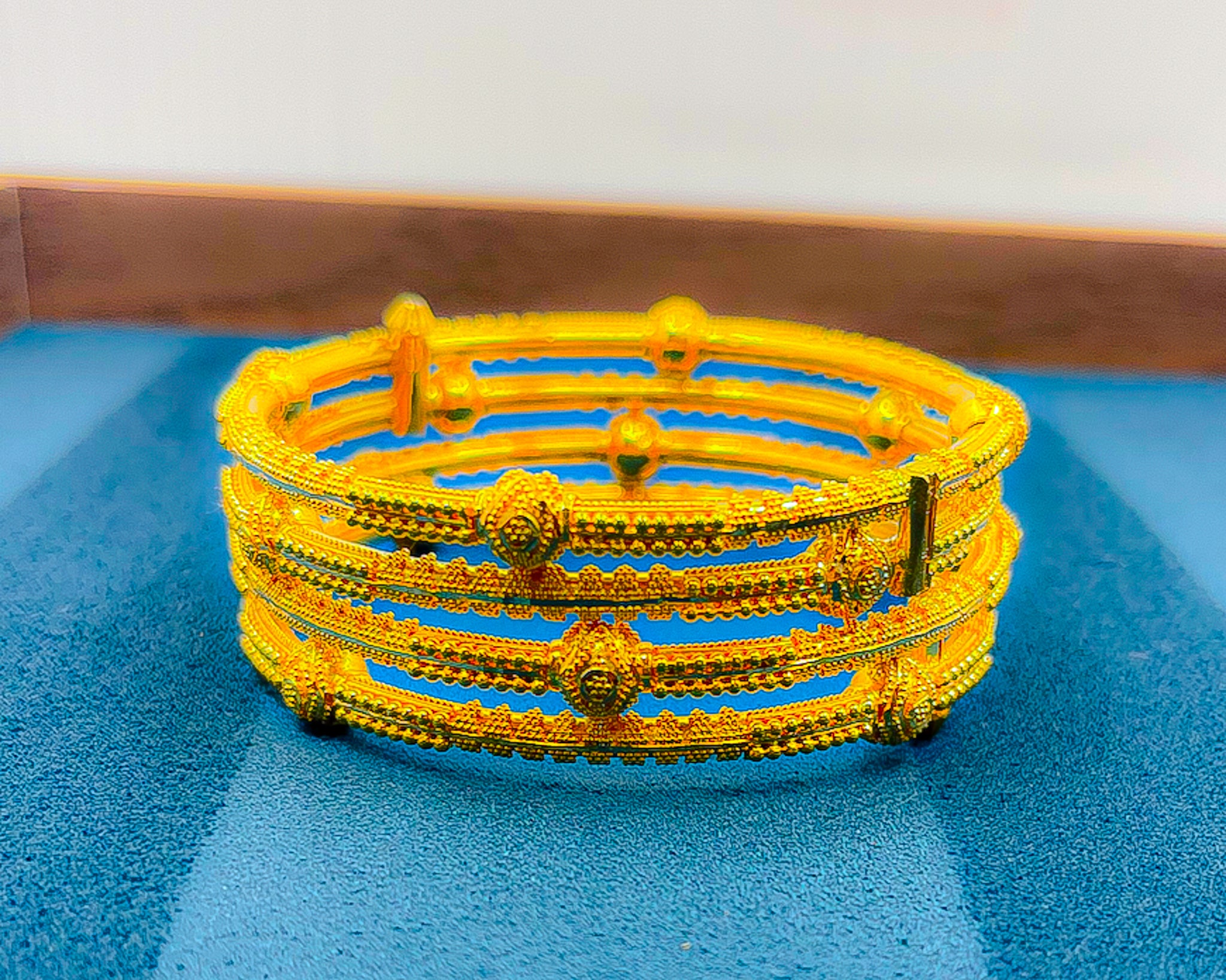 Close-up of 22K yellow gold bangle bracelet set (2 PCS) showing detailed texture