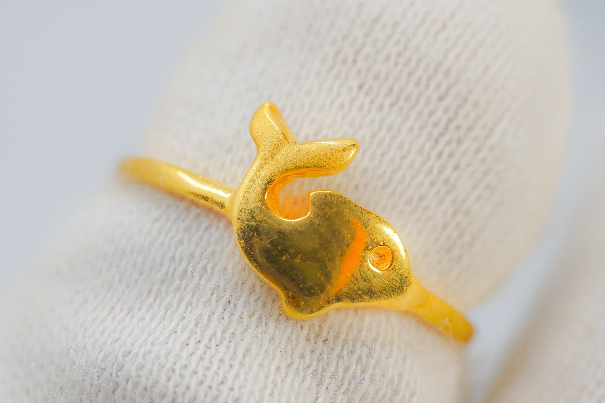 Close-up of a 22k gold fish-shaped ring (1.39g) on a white jewelry display.
