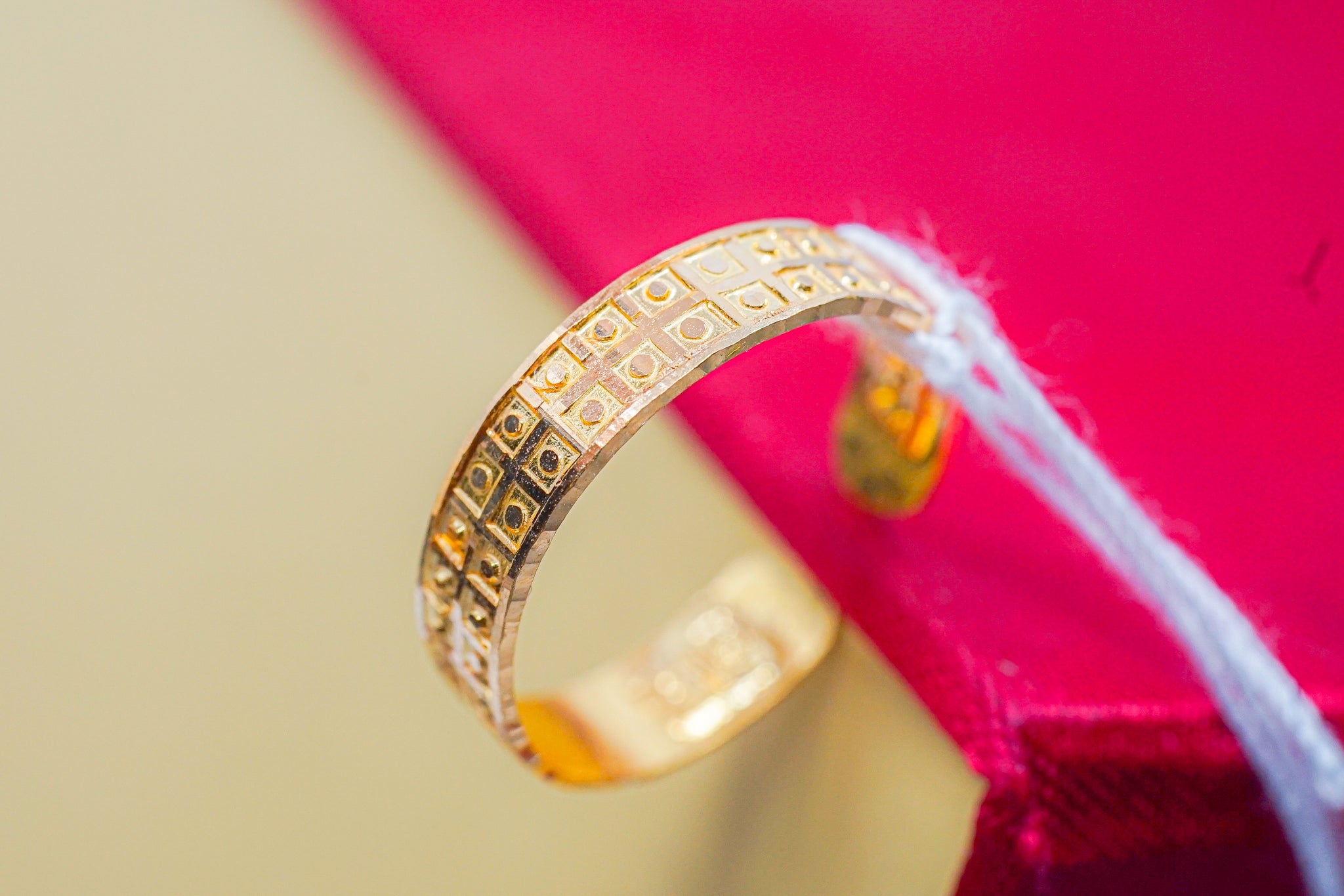 Front view of 22K solid gold geometric band ring 2.14 g on red box