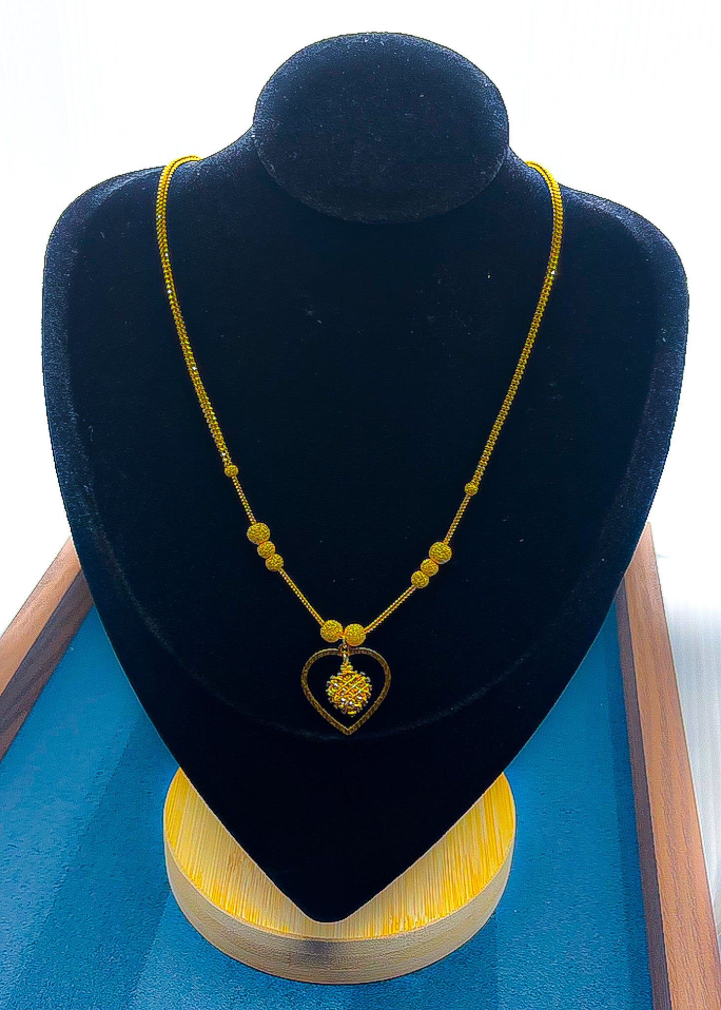 22k gold heart pendant necklace on black velvet display bust