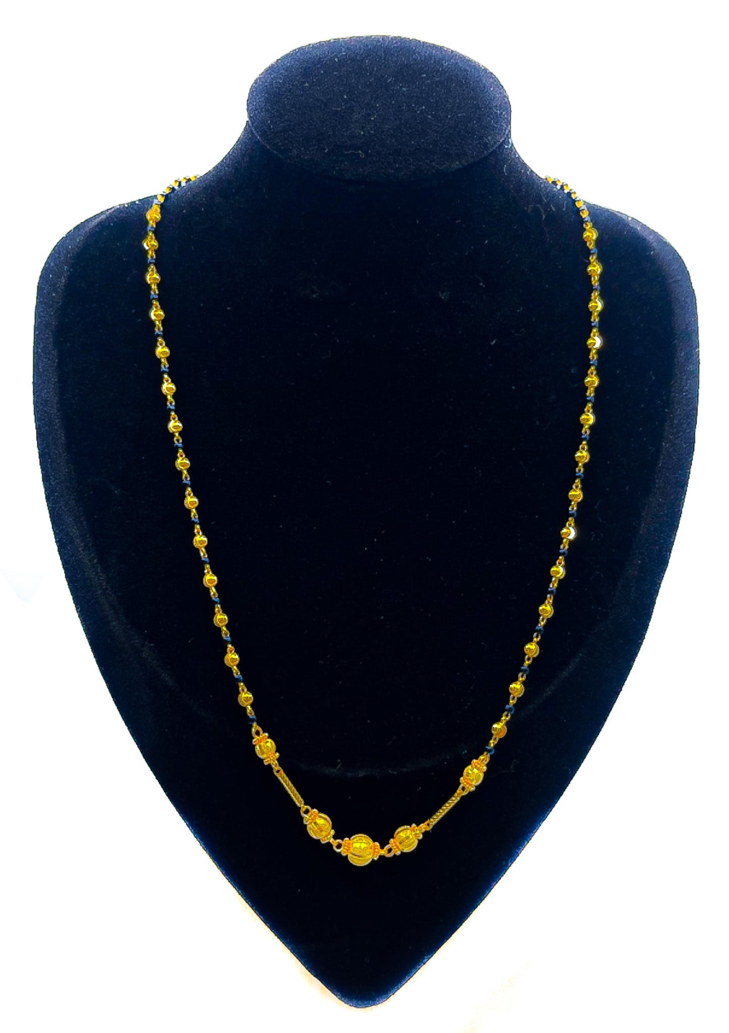 22k gold mangalsutra-style necklace 8.59g with black bead accents on a blue velvet mannequin bust