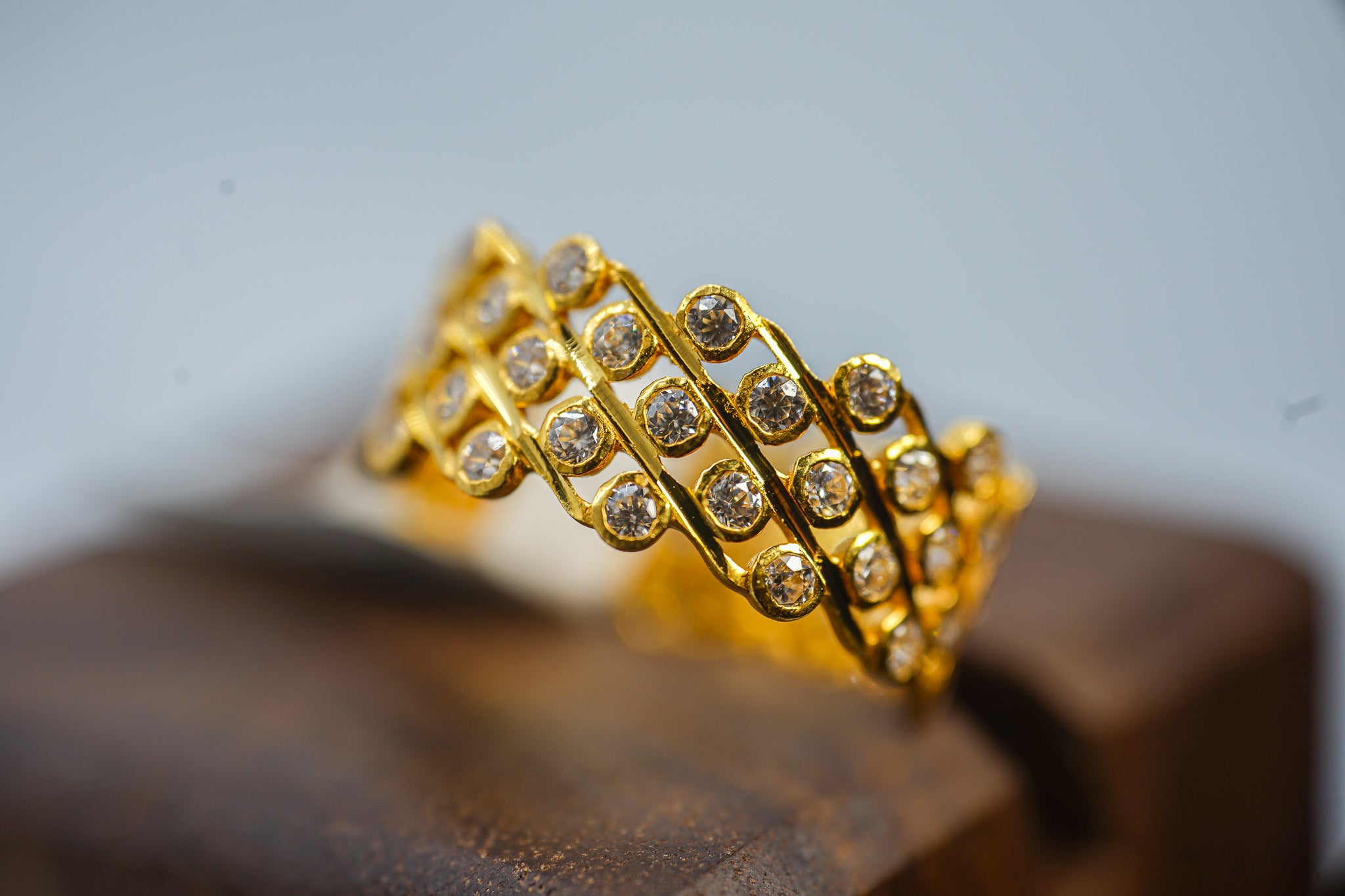 22K gold multi-row band ring with clear round stones shown from the front.