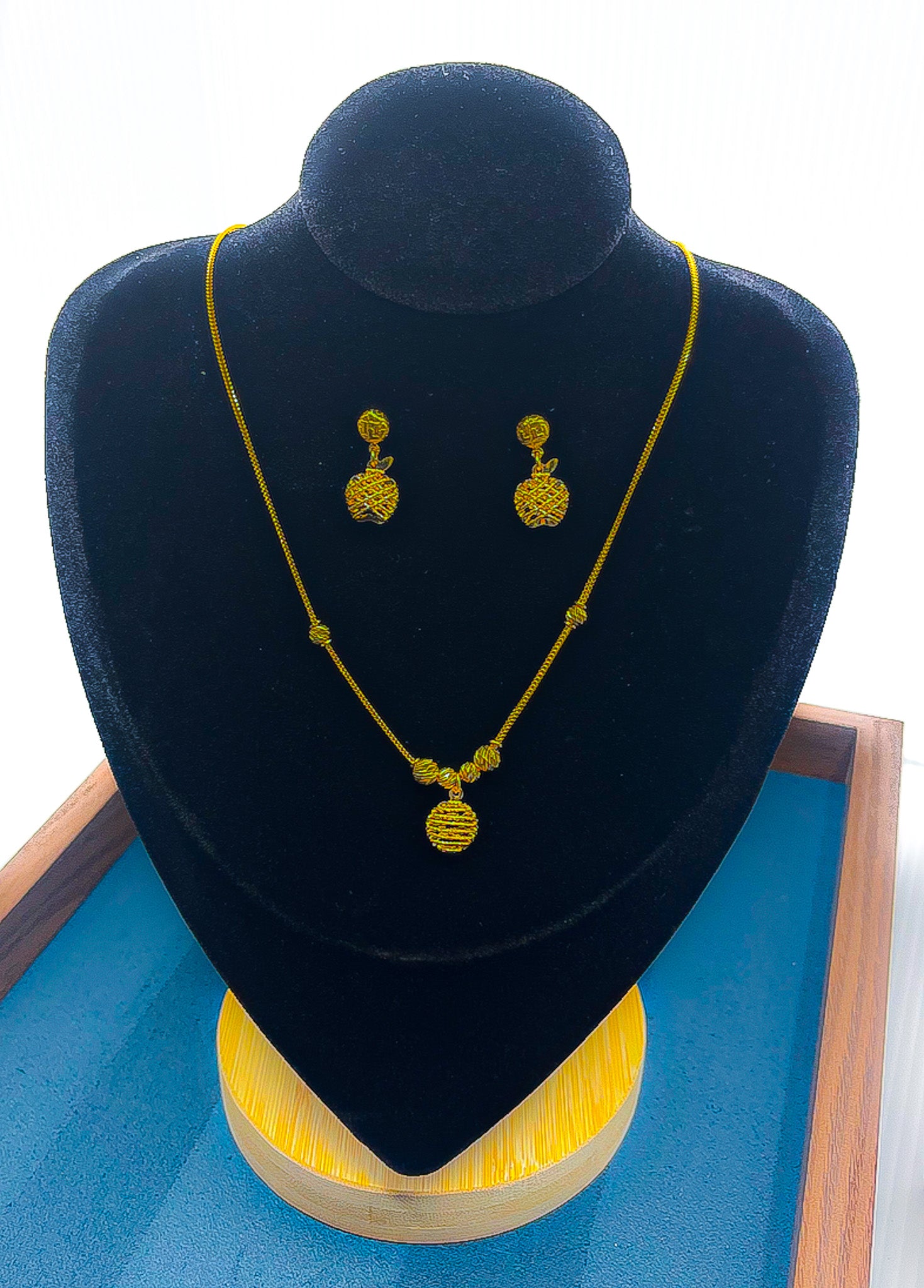 22K gold necklace and matching drop earrings set, 10.37 g, displayed on black velvet bust