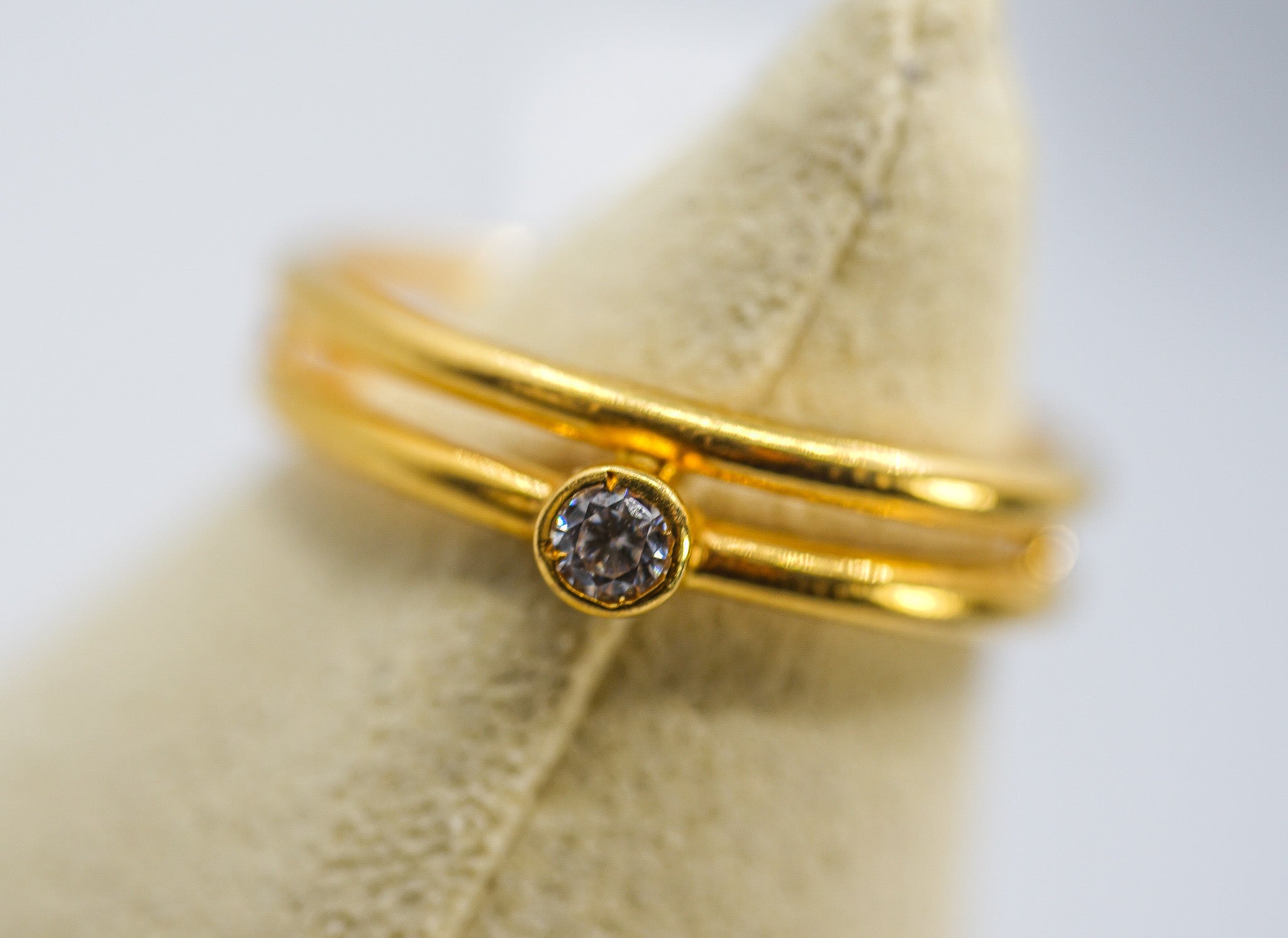 22K gold ring with a bezel-set round stone and a slim multi-band design, size 6.5