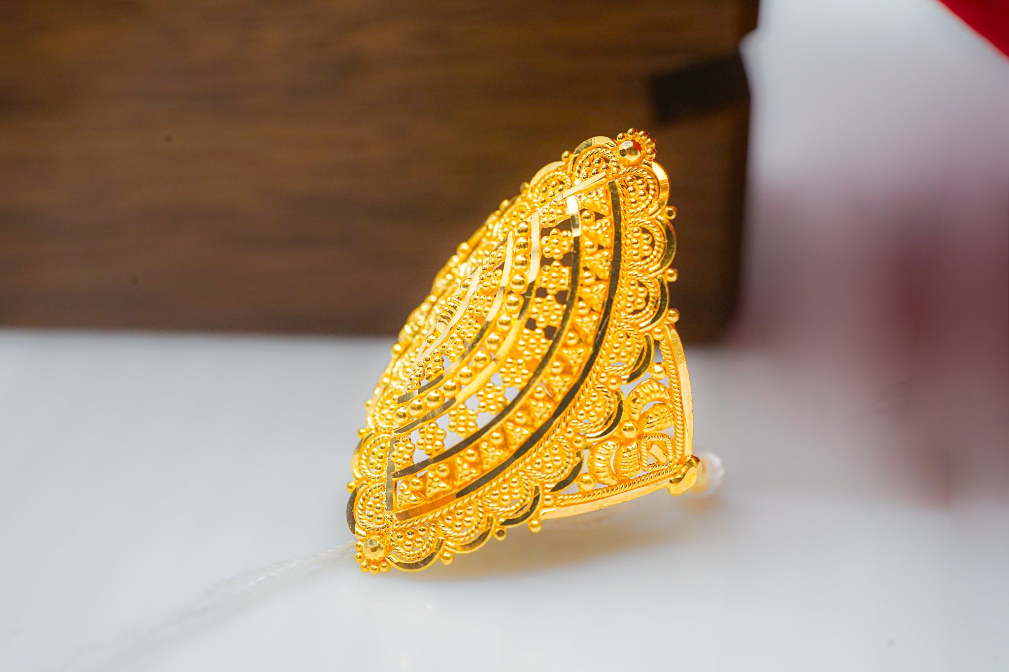 22k gold statement ring with an ornate filigree-style face.