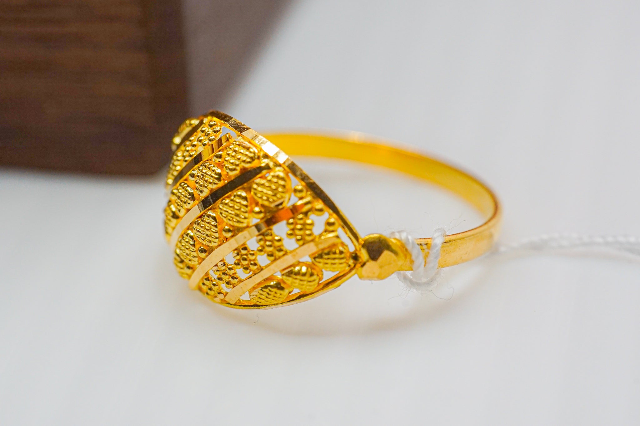 22k striped dome gold ring with beaded texture on a white background