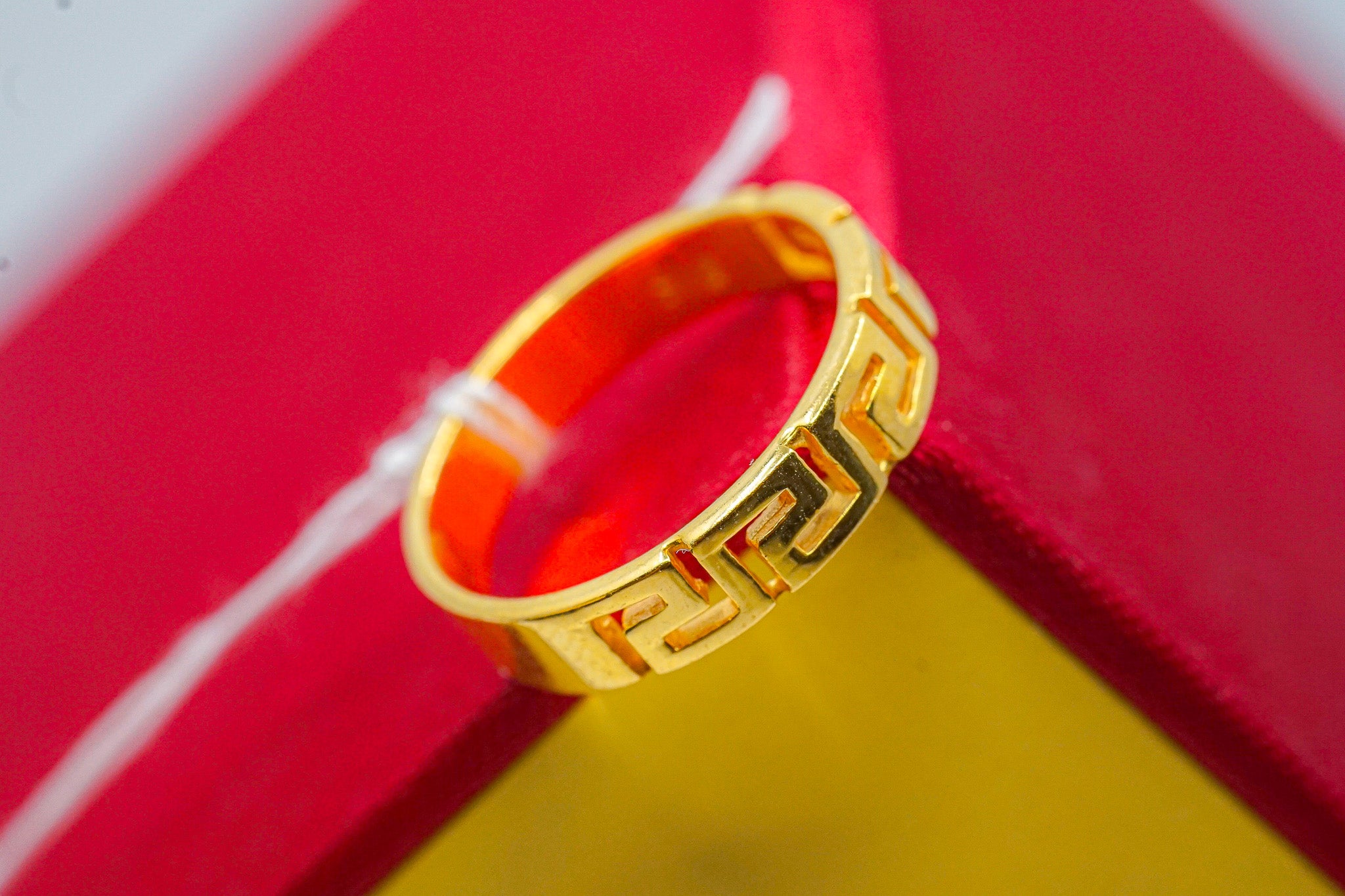 22k gold Greek key band ring, geometric pattern, 4.15g, on red and yellow background