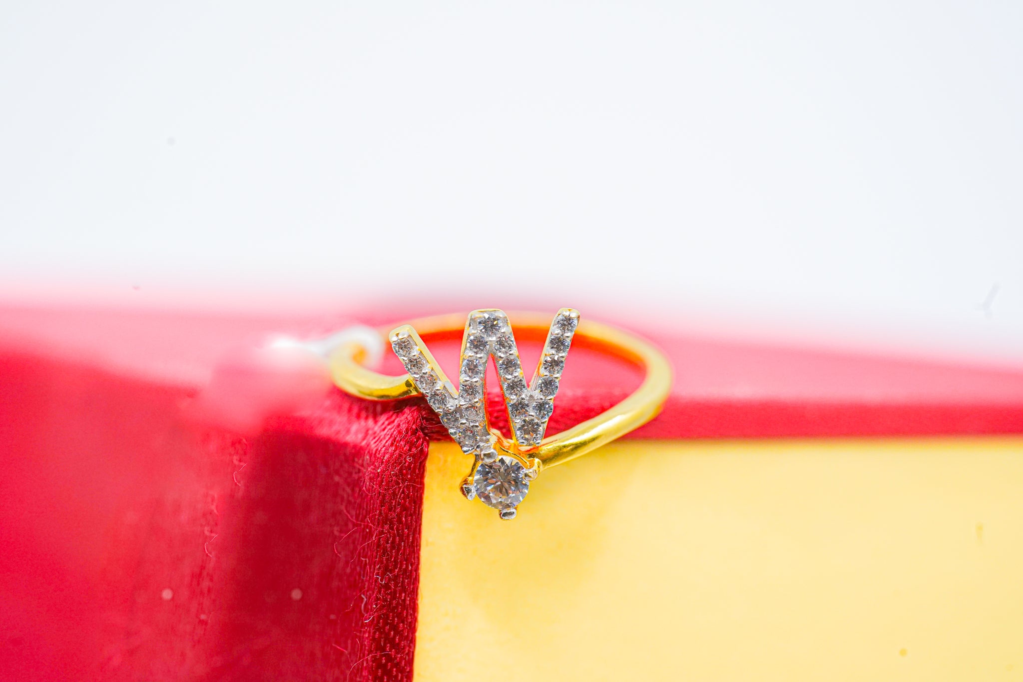 Short video of a 22k gold W initial ring with zircon stones, rotating on a jewelry stand