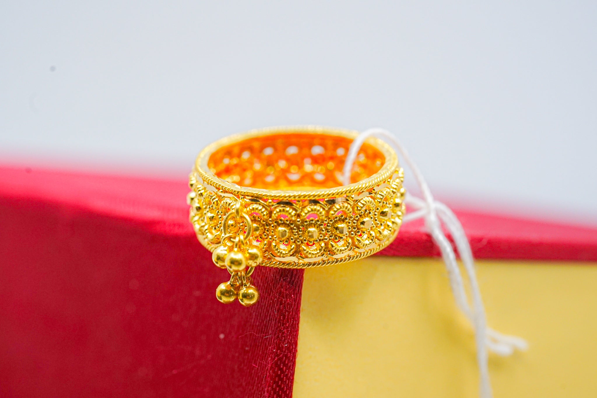 22k gold filigree beaded ring with dangle charm on red and yellow display box
