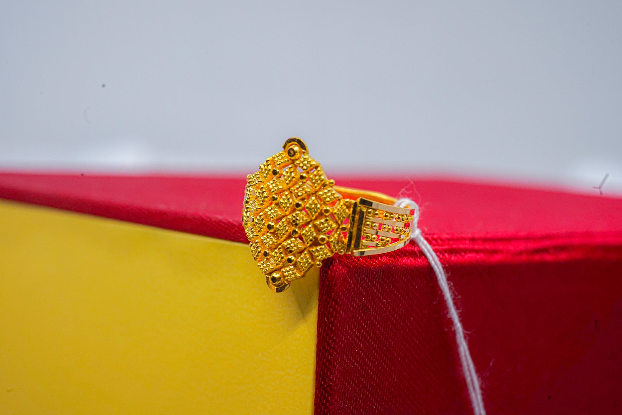 22k gold lattice dome ring on red and yellow jewelry box, 2.76 gram weight