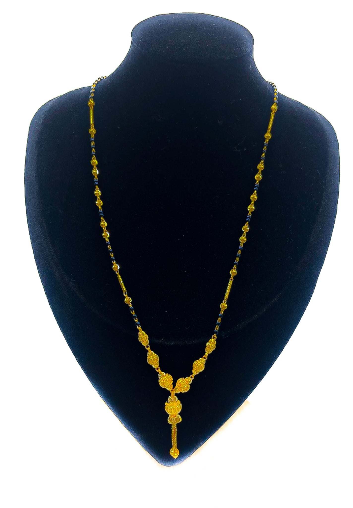 22k gold mangalsutra-style necklace with black-bead accents and pendant drop on a black mannequin bust