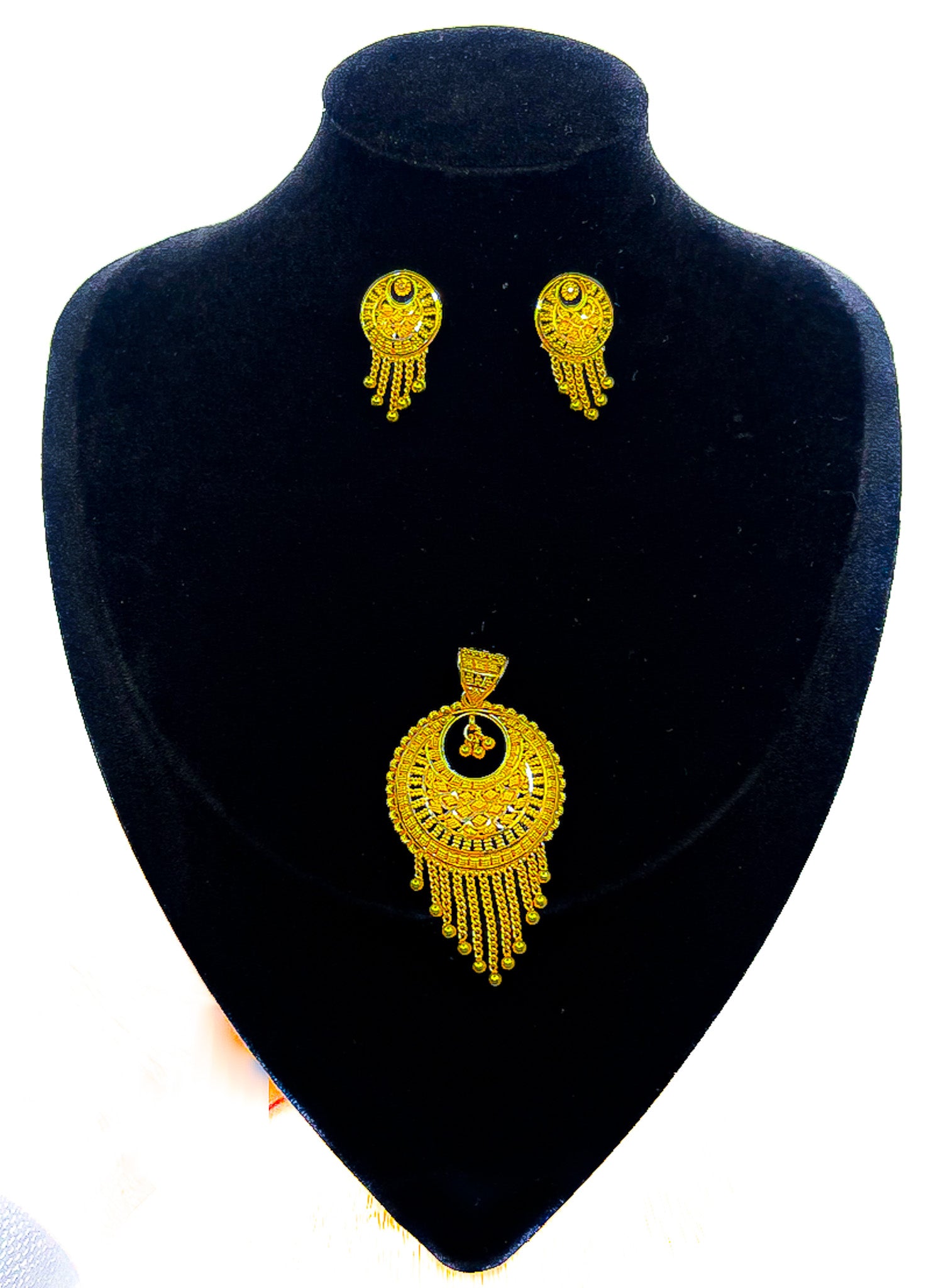 22k gold pendant and matching earrings set with fringe dangle design on a black jewelry display bust.