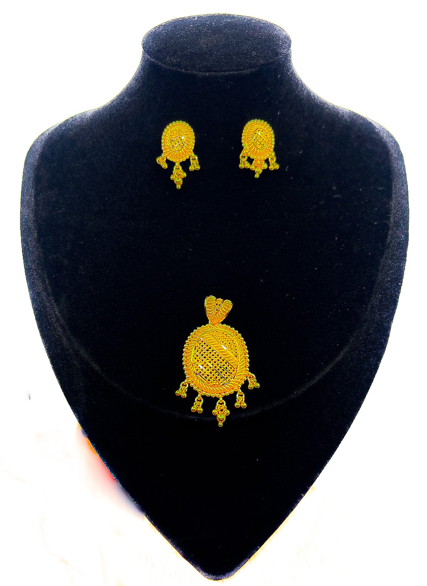 22k gold pendant and matching earrings set on black velvet display