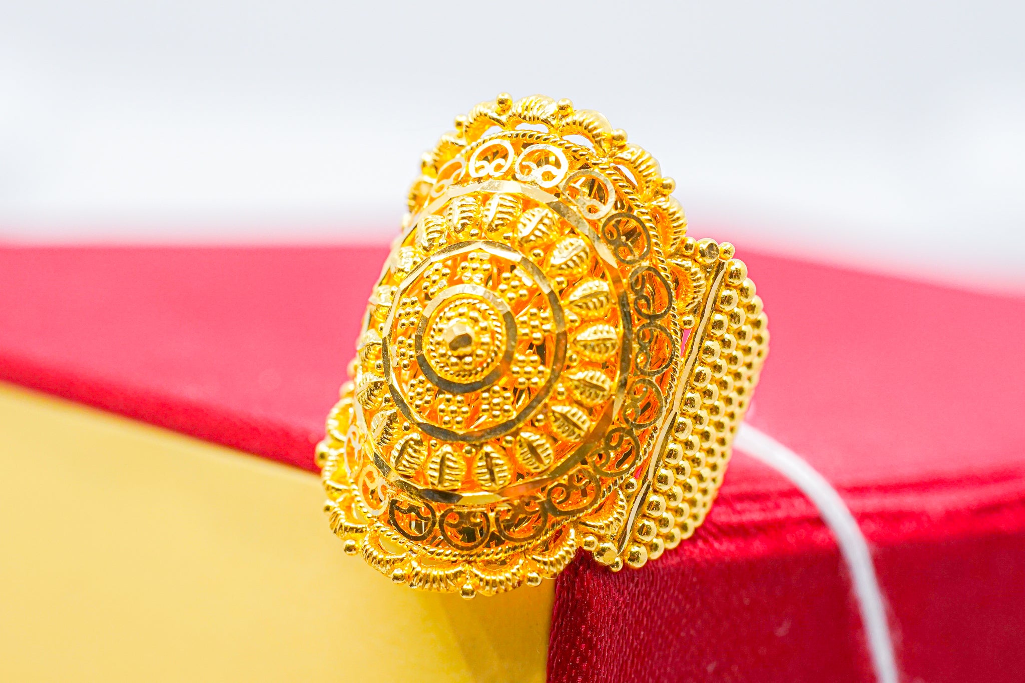 22k gold statement ring with large round filigree medallion face on red and yellow box
