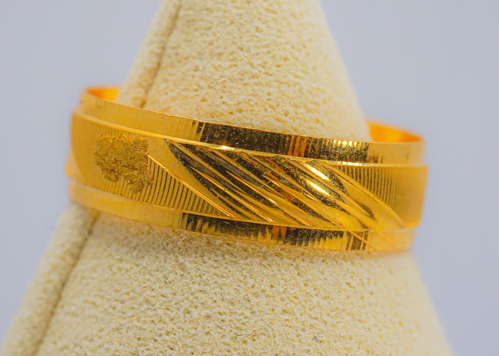 22k gold textured band ring with diagonal engraved center detail, size 8 (2.69g), shown on a jewelry display cone.