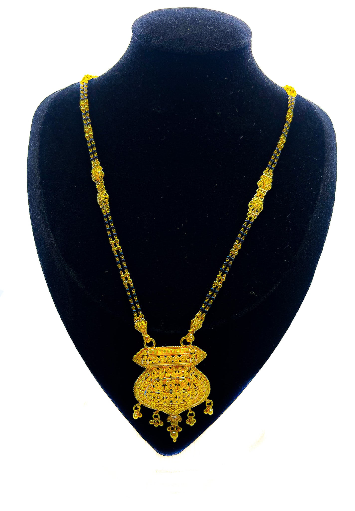 22k yellow gold necklace with black beaded chain and large statement pendant displayed on black velvet mannequin bust