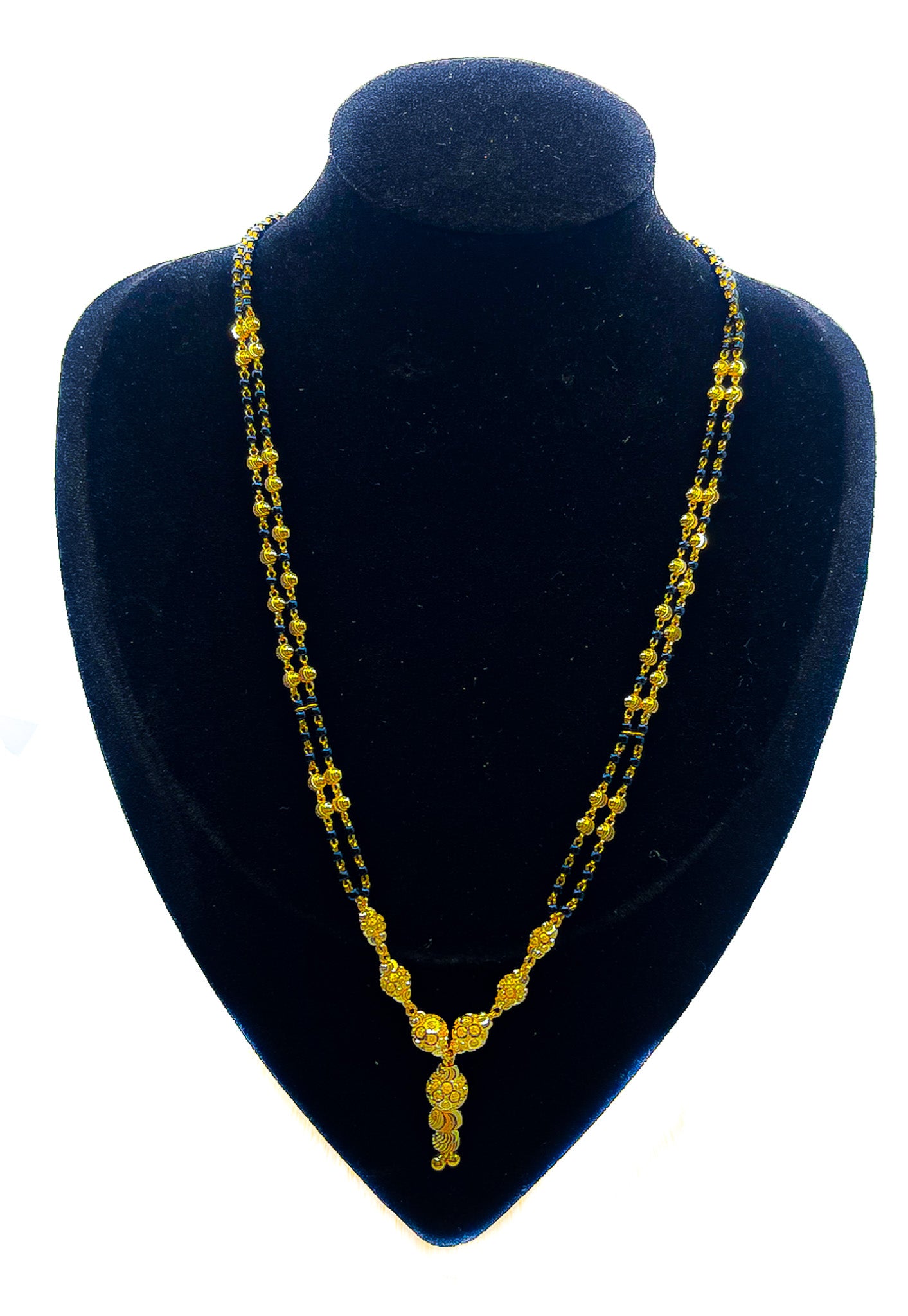 22k yellow gold necklace with blue bead accents and drop pendant detail displayed on black velvet mannequin