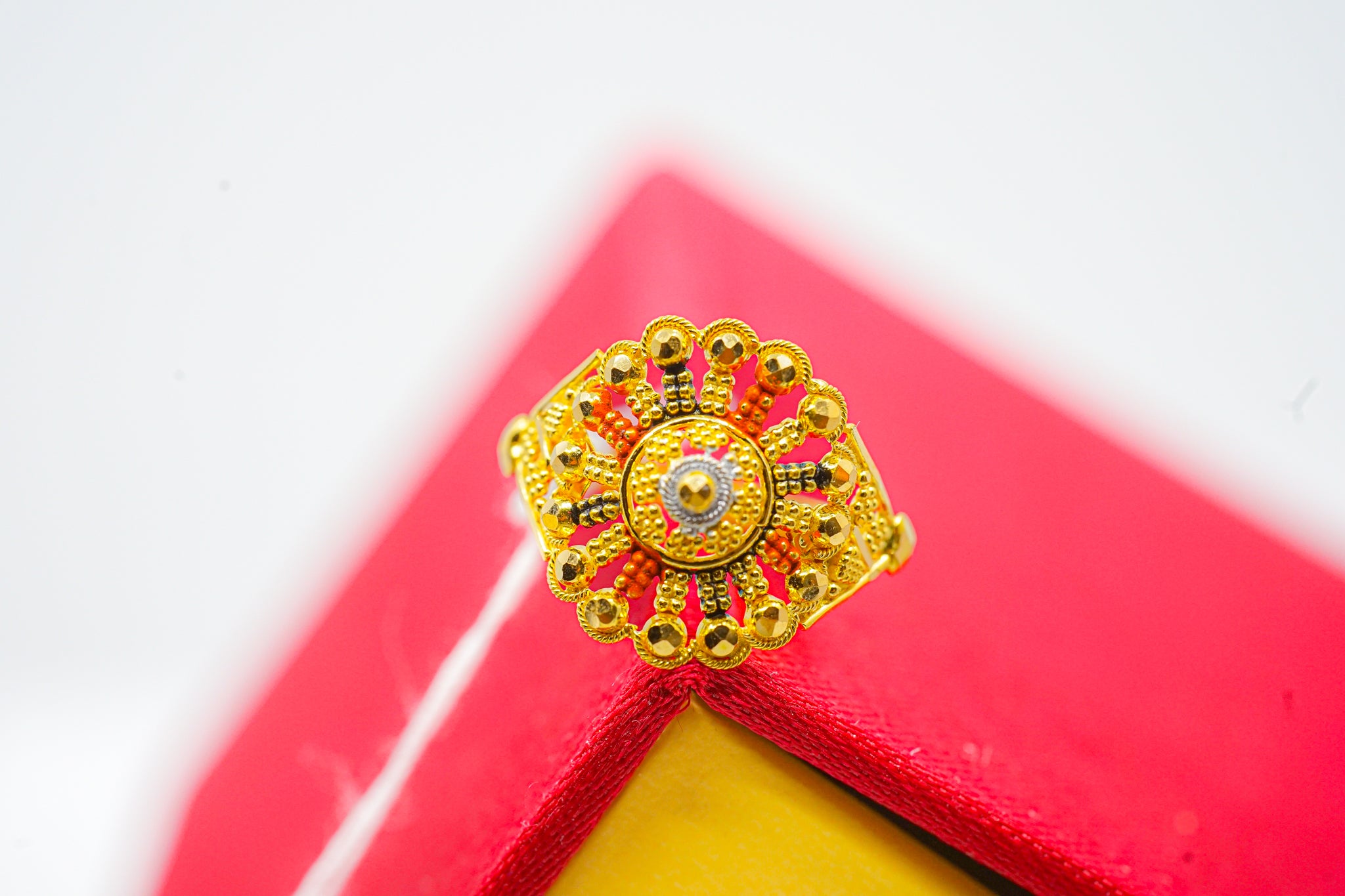 front view of 22k gold floral beaded statement ring on display stand