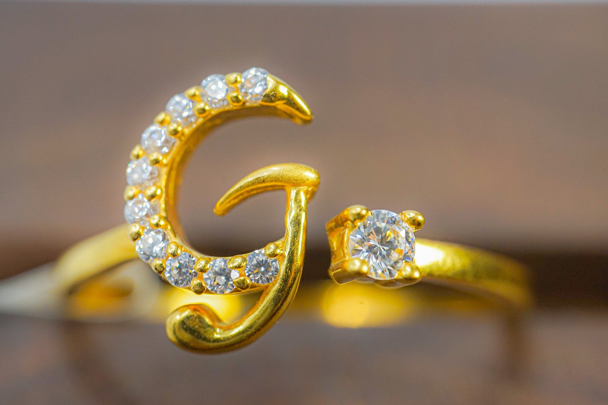 Front view of 22k yellow gold initial G ring with clear stone accents.
