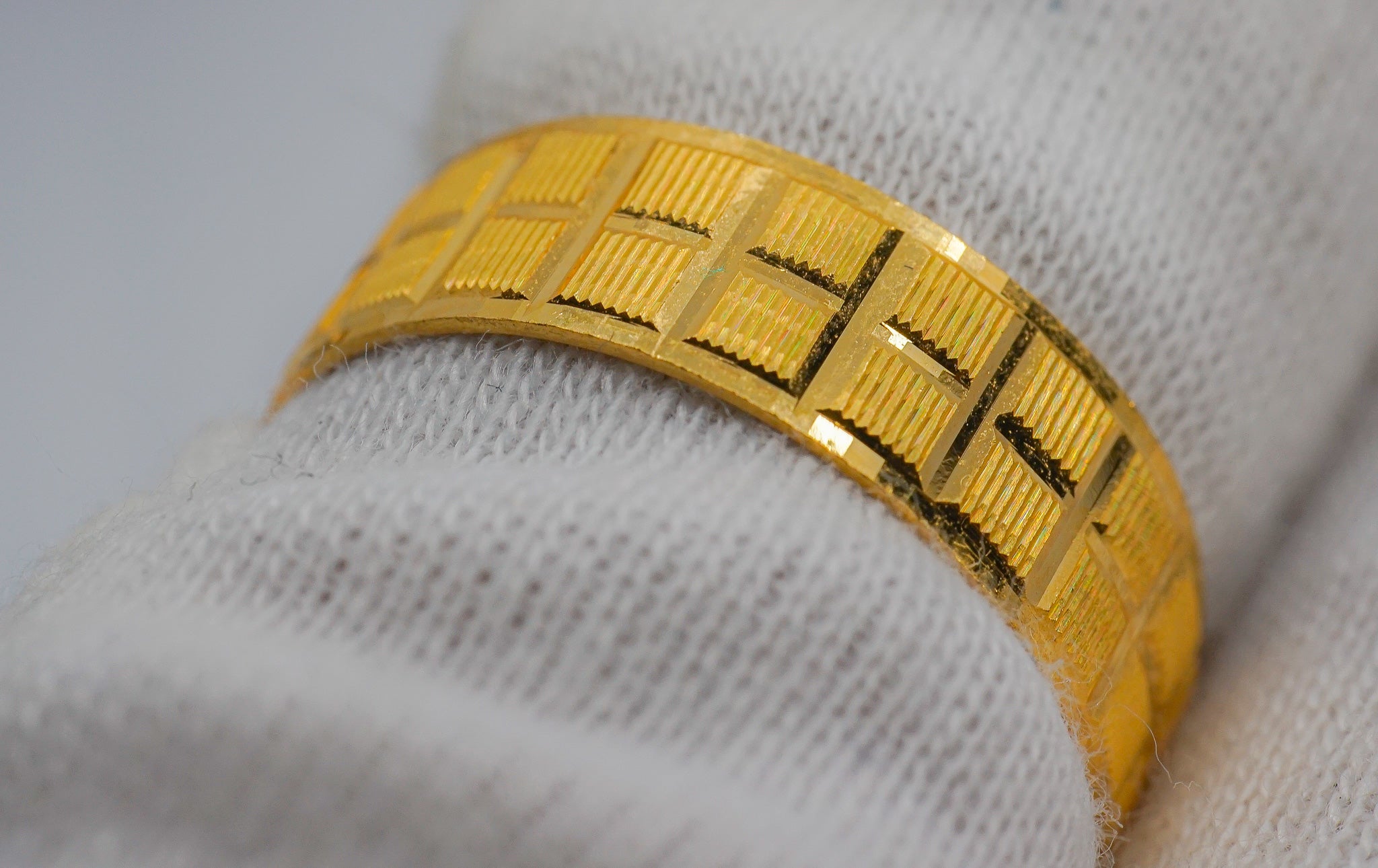 Angled view of 22K gold geometric patterned band ring, size 7, showing the textured rectangular design.