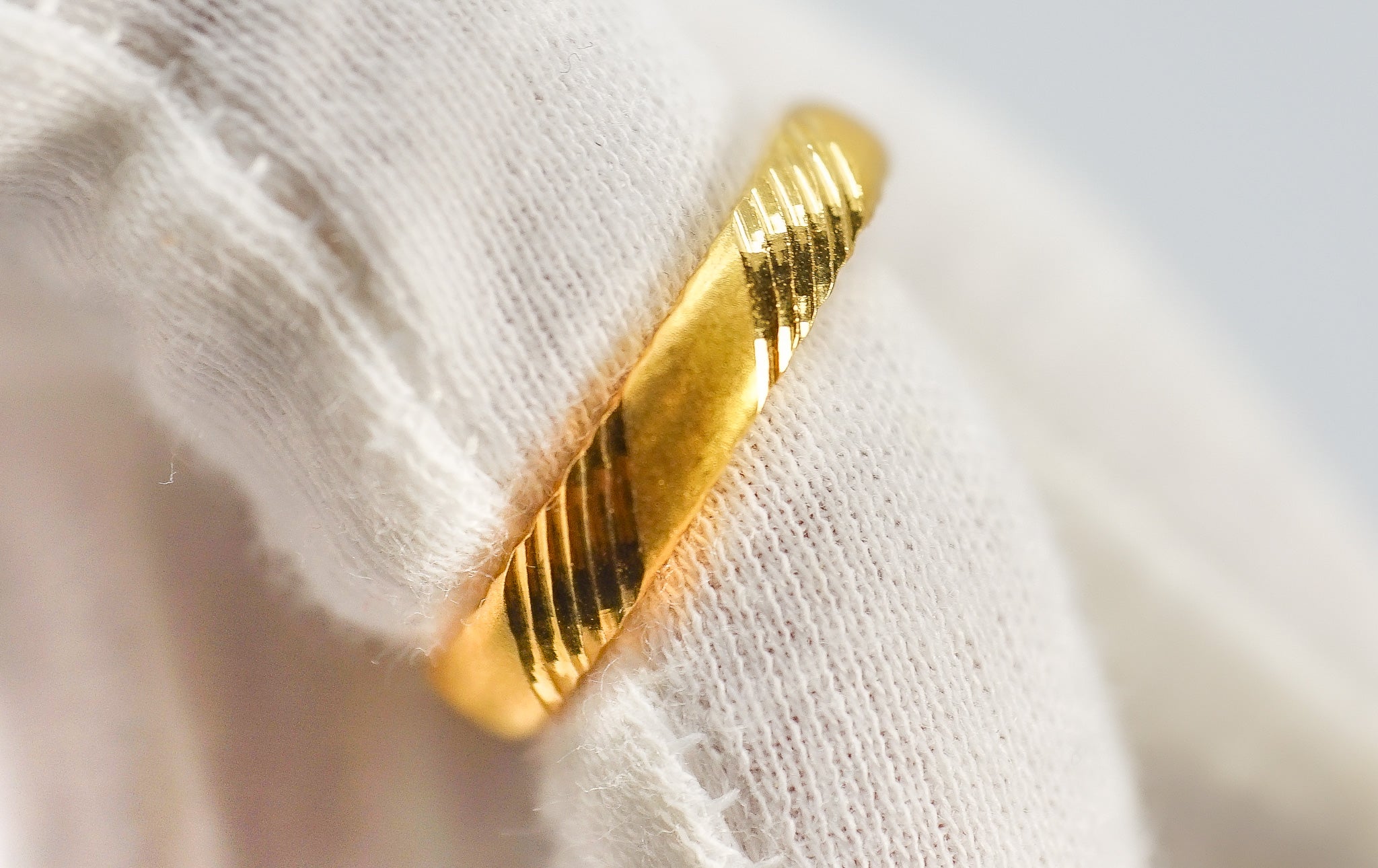 Close-up of 22K gold band ring showing striped texture pattern, size 7.5