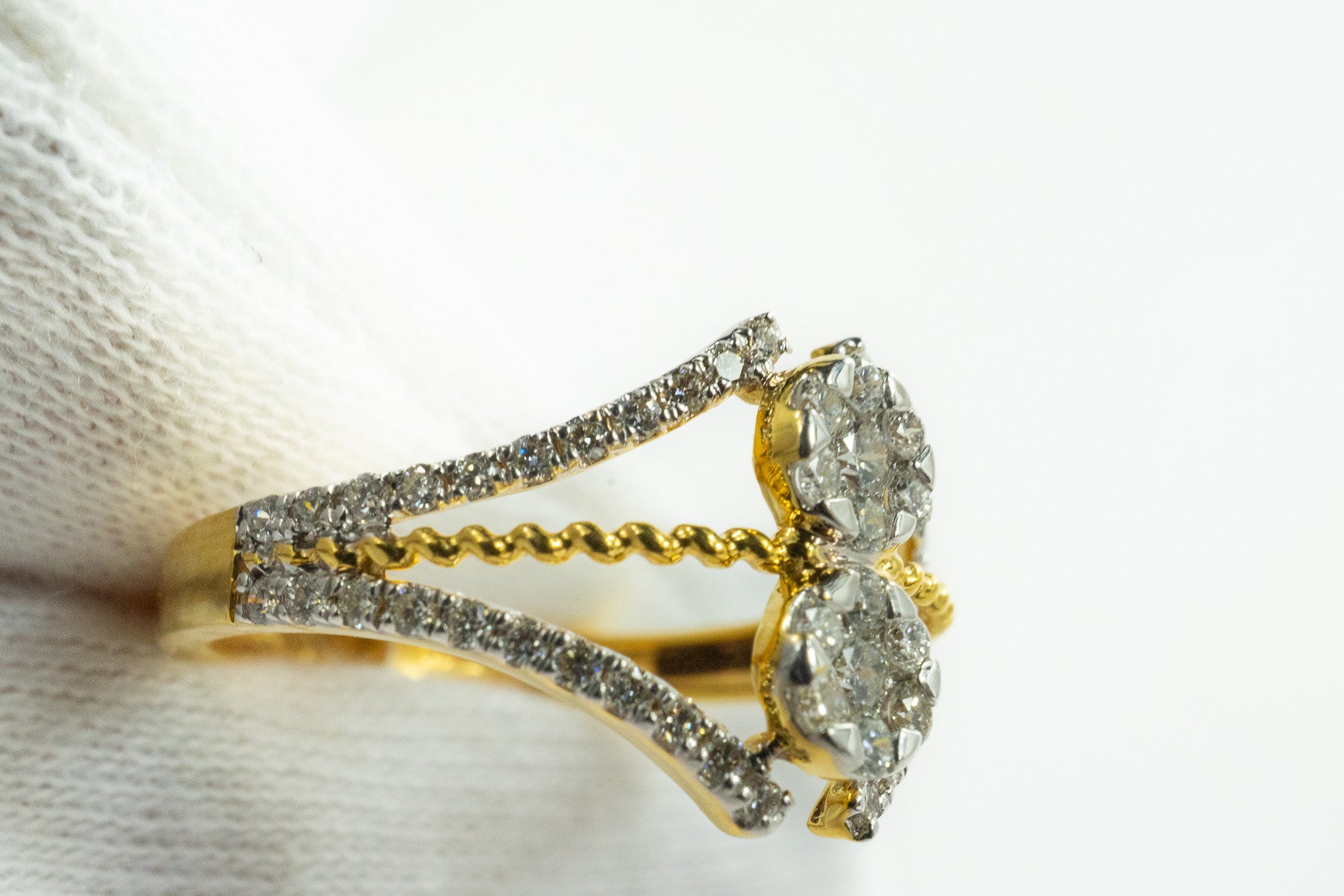 Close-up of Moonbeam 18k gold two-stone diamond cluster ring showing pavé accents and split shank design.