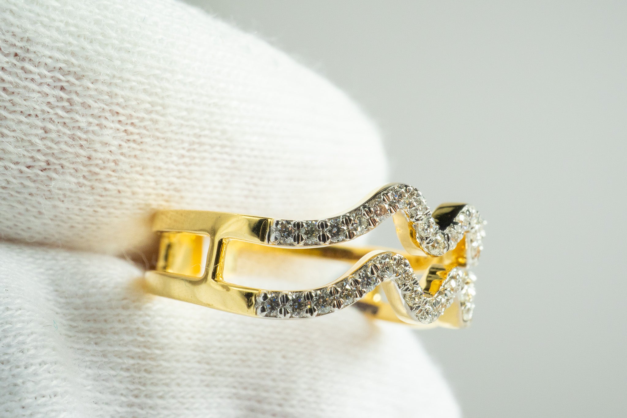 Close-up of Velvet Dust Ring in 18k gold with wave pavé diamonds and split-band design, 0.25 carat total diamond weight.