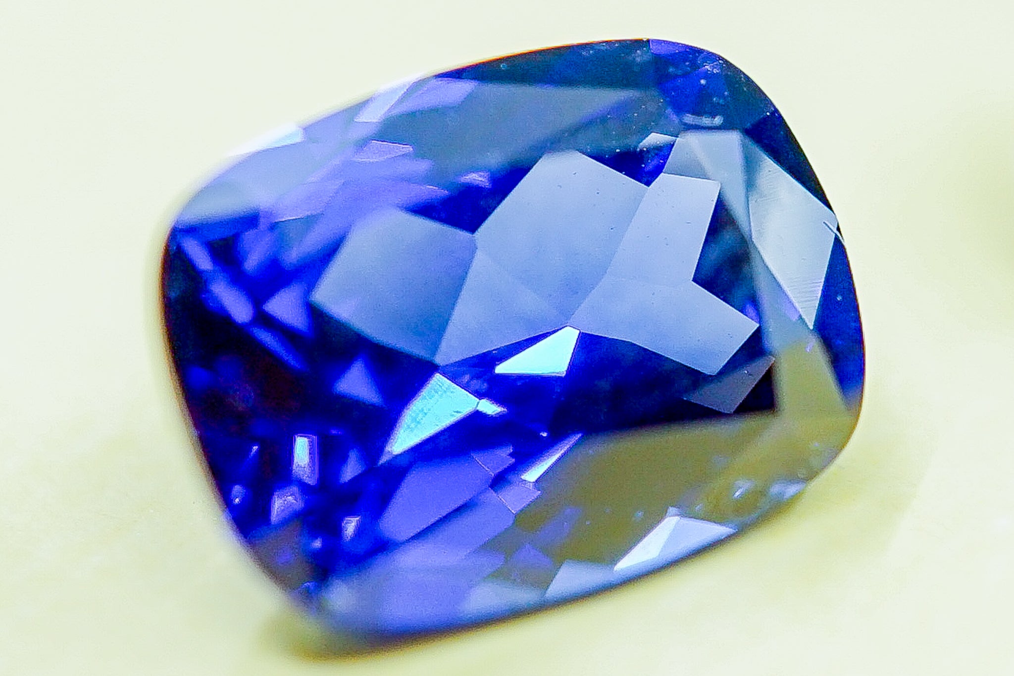 Close-up of a blue sapphire gemstone from another angle showing the faceted cut and shine.