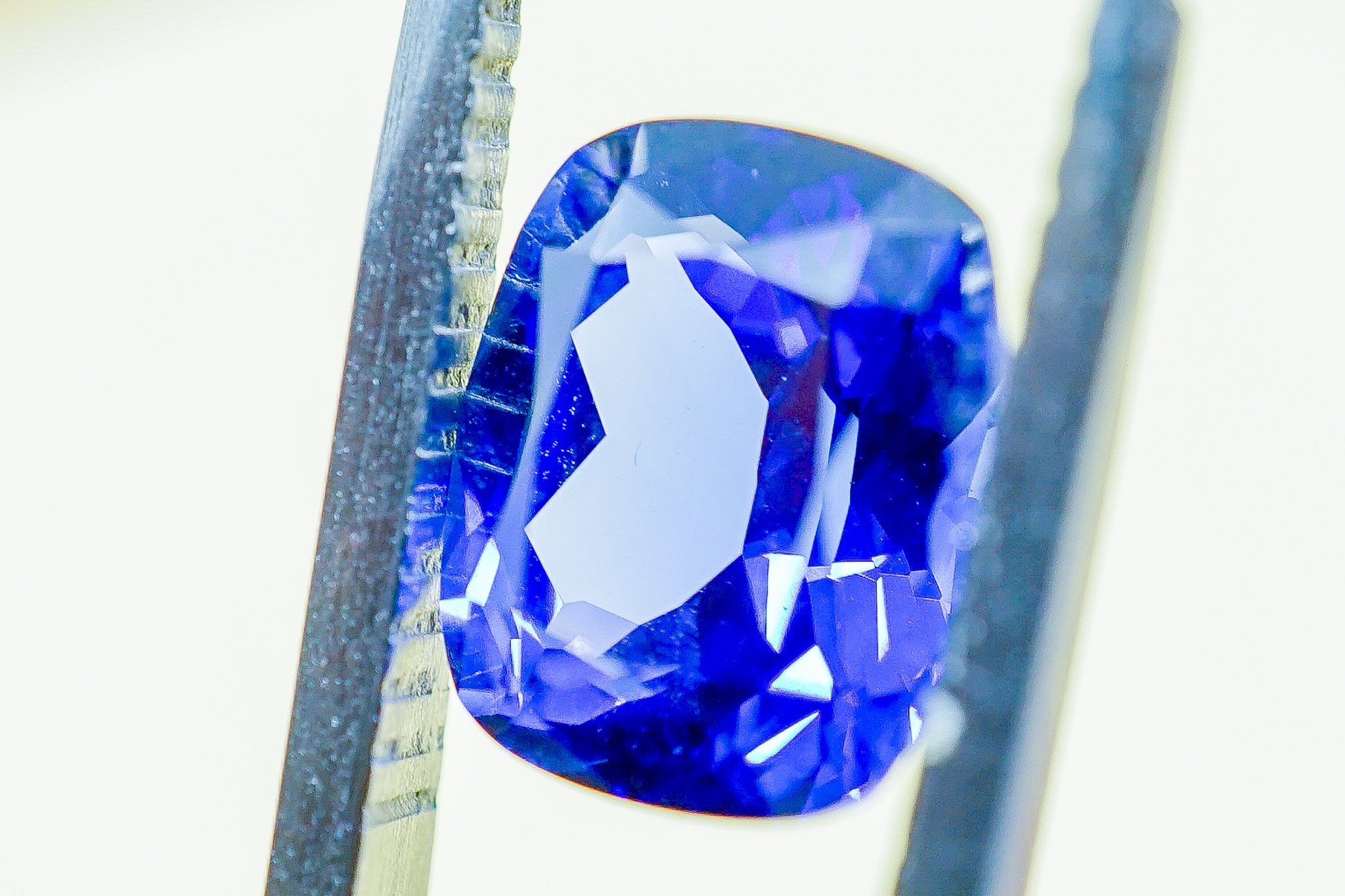 Close-up view of faceted blue sapphire loose stone, cushion shape