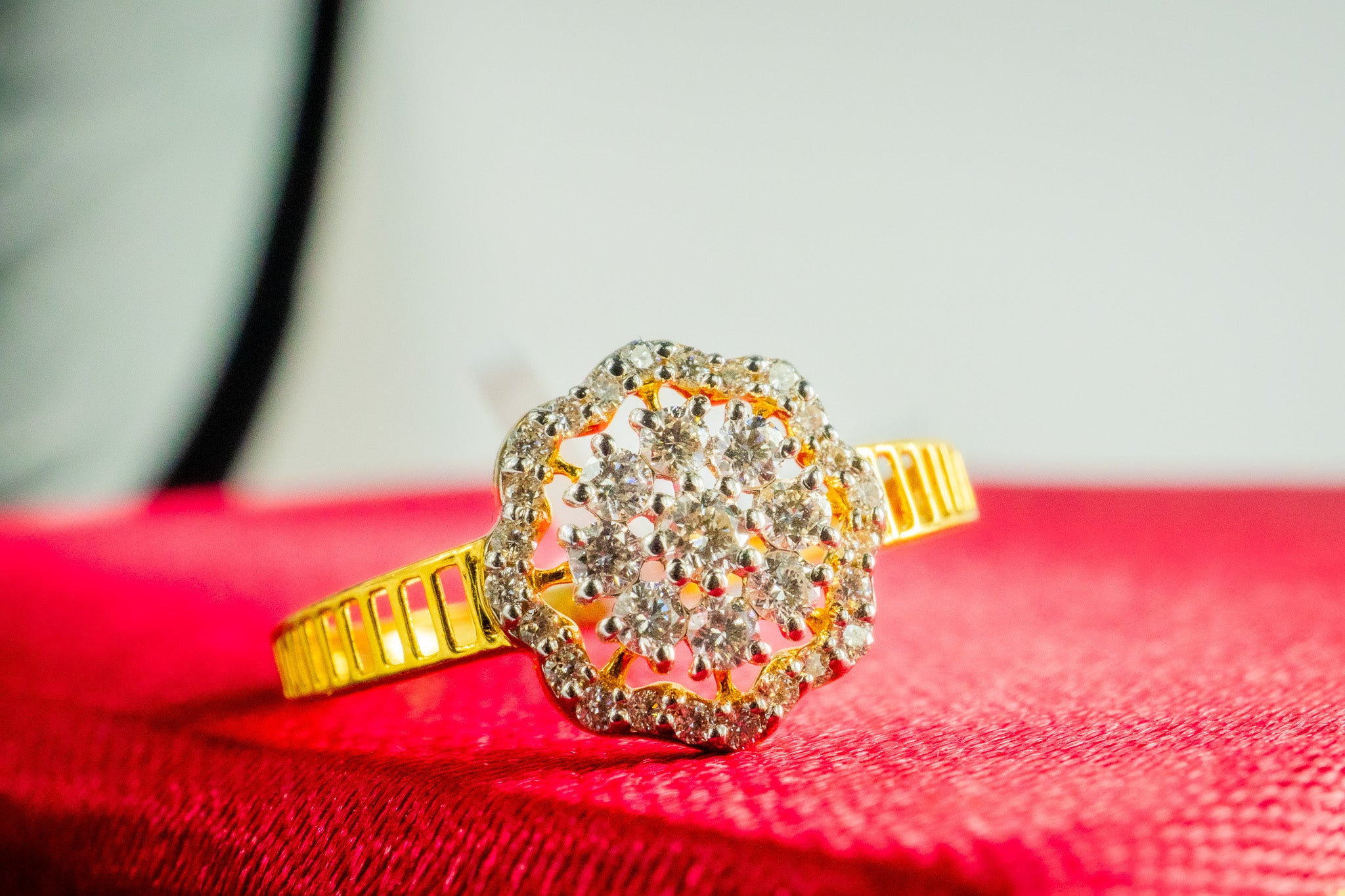 Front view of 18k yellow gold diamond halo cluster ring on red jewelry box