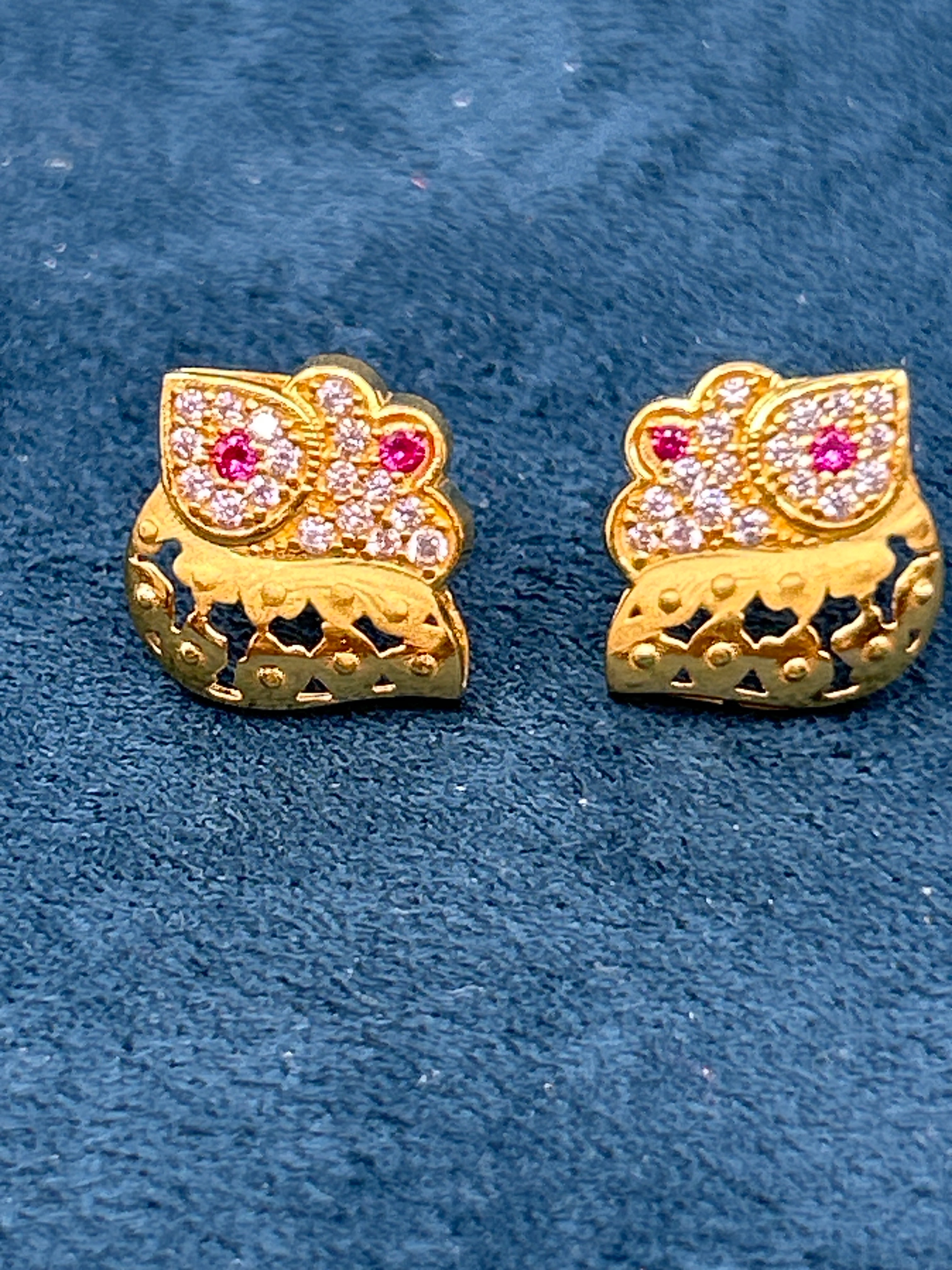 Gold earrings with gemstones on a blue background