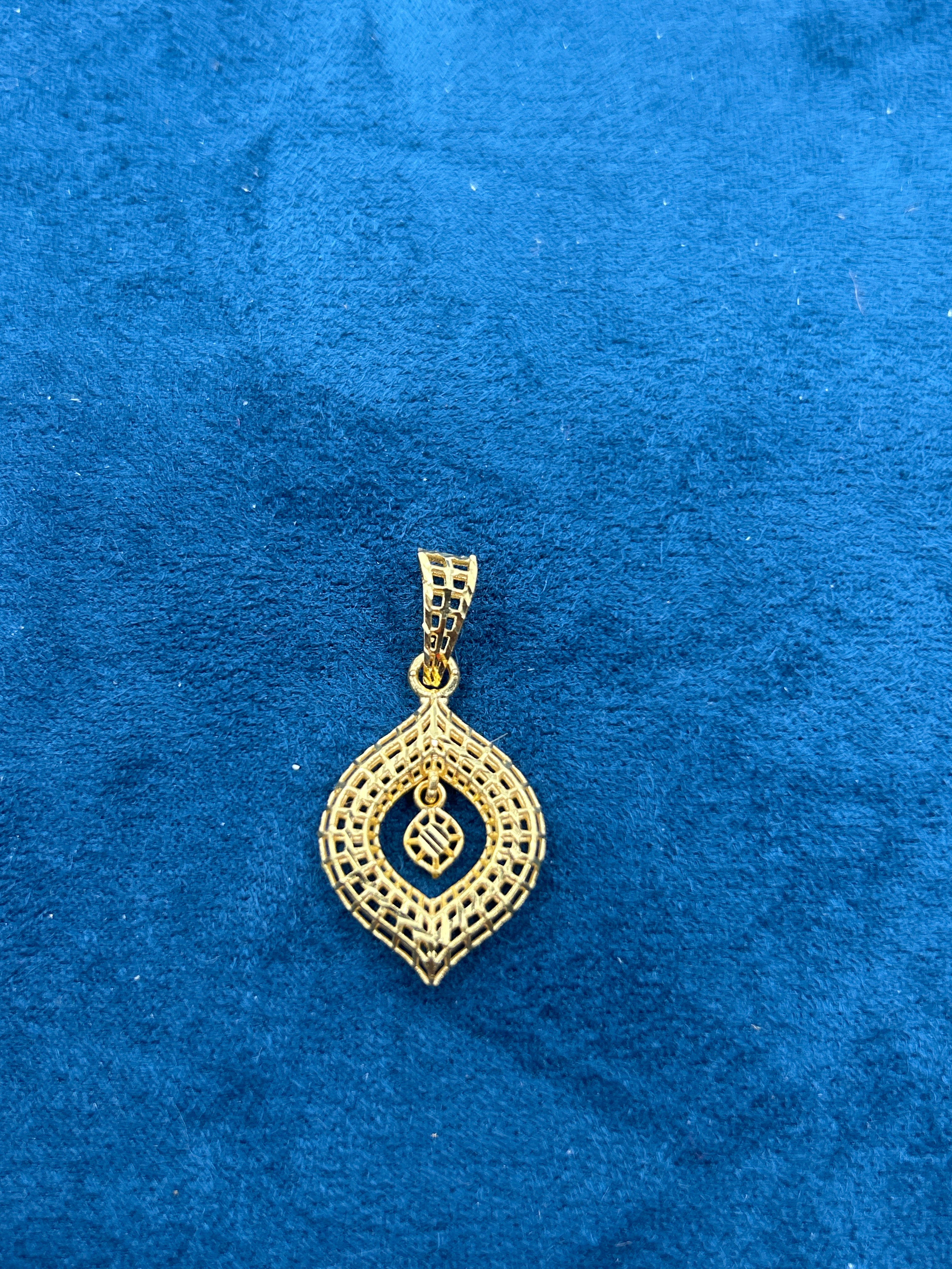Gold pendant on a blue textured background