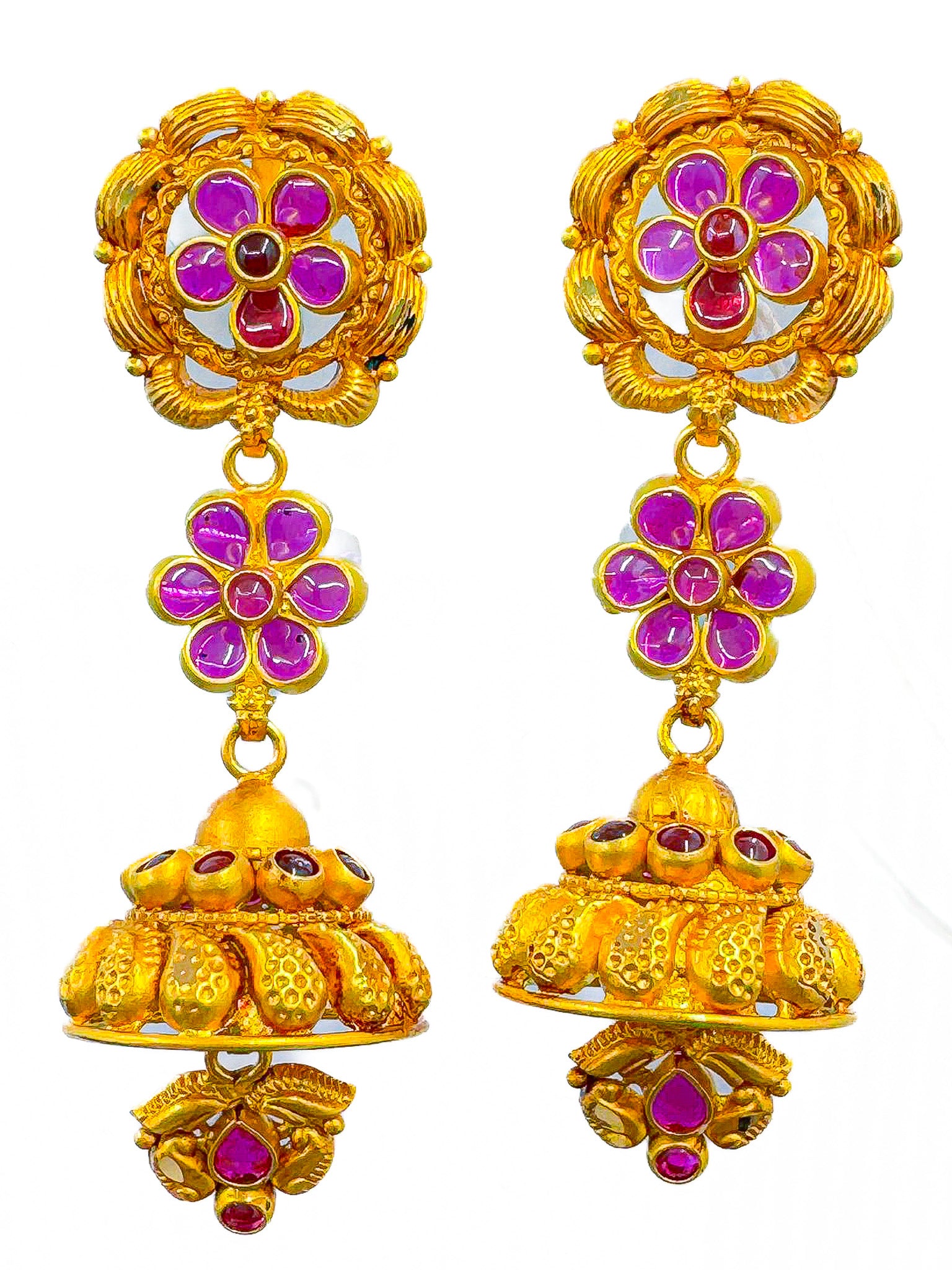 Pair of 22k gold jhumka earrings with floral design and pink and red stones on a white background.