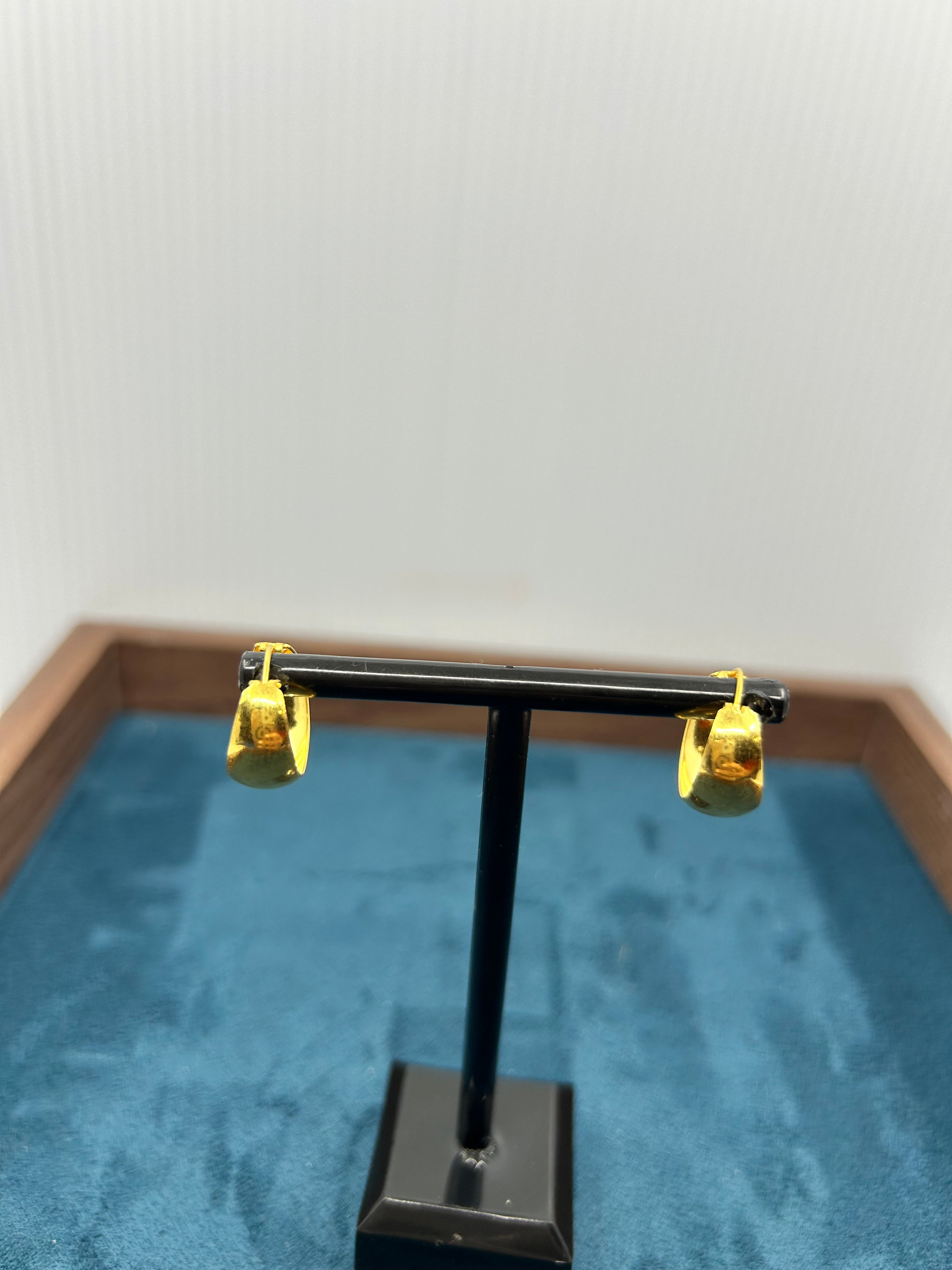 Pair of gold hoop earrings (4.78g) displayed on a black stand.