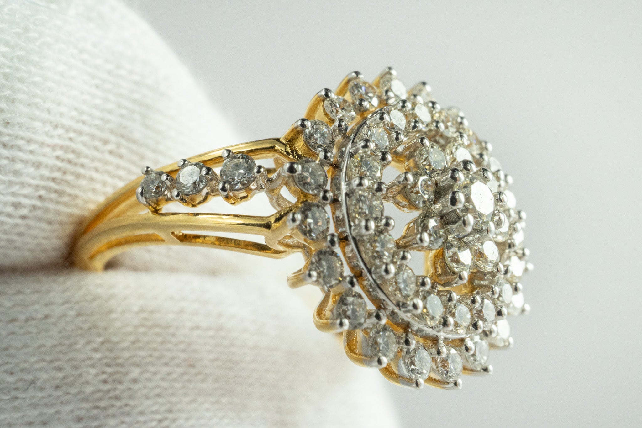 Side view of 18k gold diamond cluster ring showing raised halo-style setting