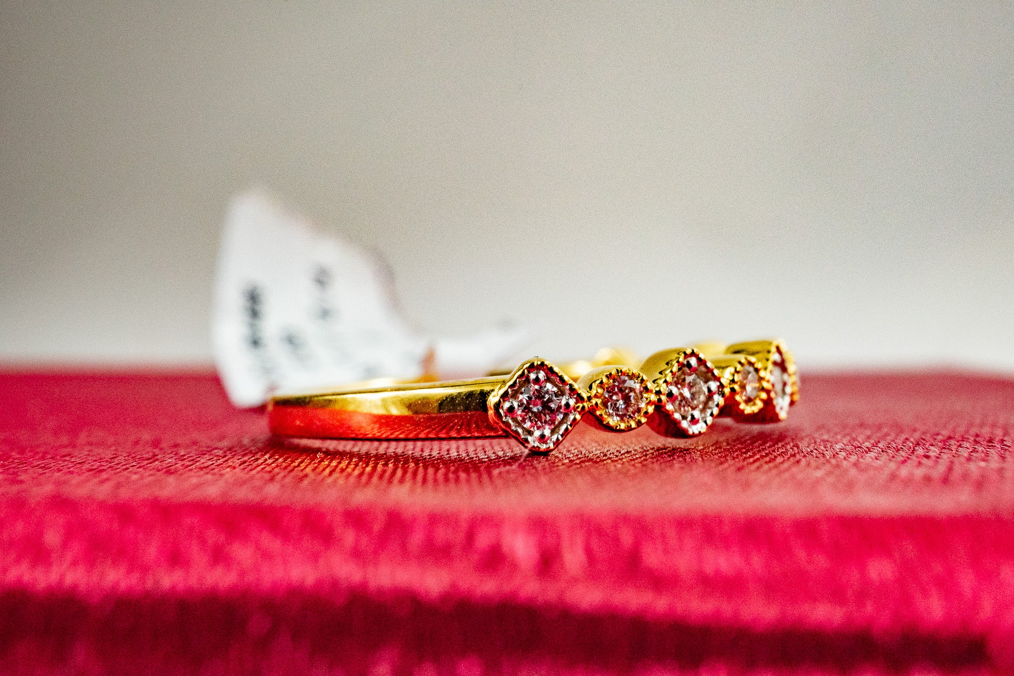 Side view of 18k gold diamond station band ring with multiple diamond accents, 0.16 CTW.