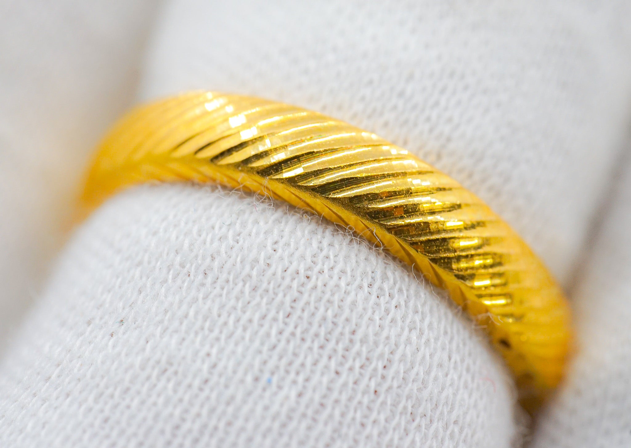 Side view of 22k gold band ring showing diagonal textured grooves, size 7