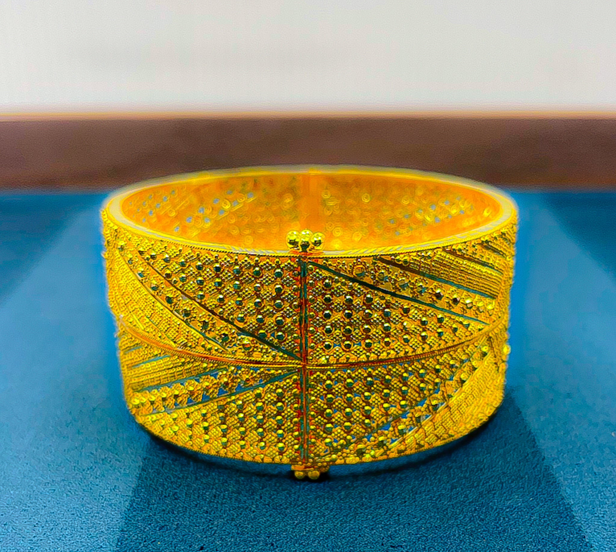 Two 22K gold bangles (2 PCS) showing detailed textured and engraved pattern in hand