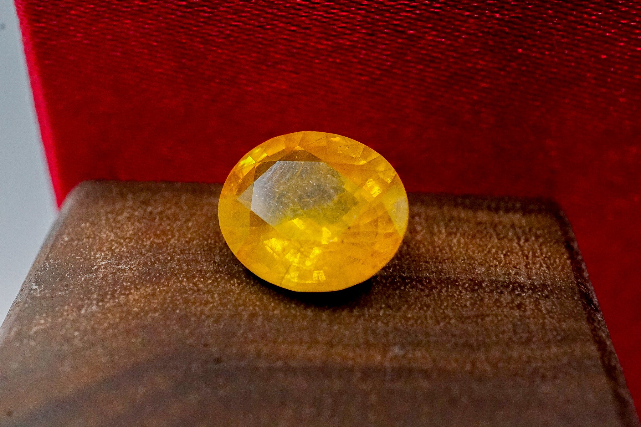 Yellow sapphire loose gemstone 1.44g faceted stone on wooden surface