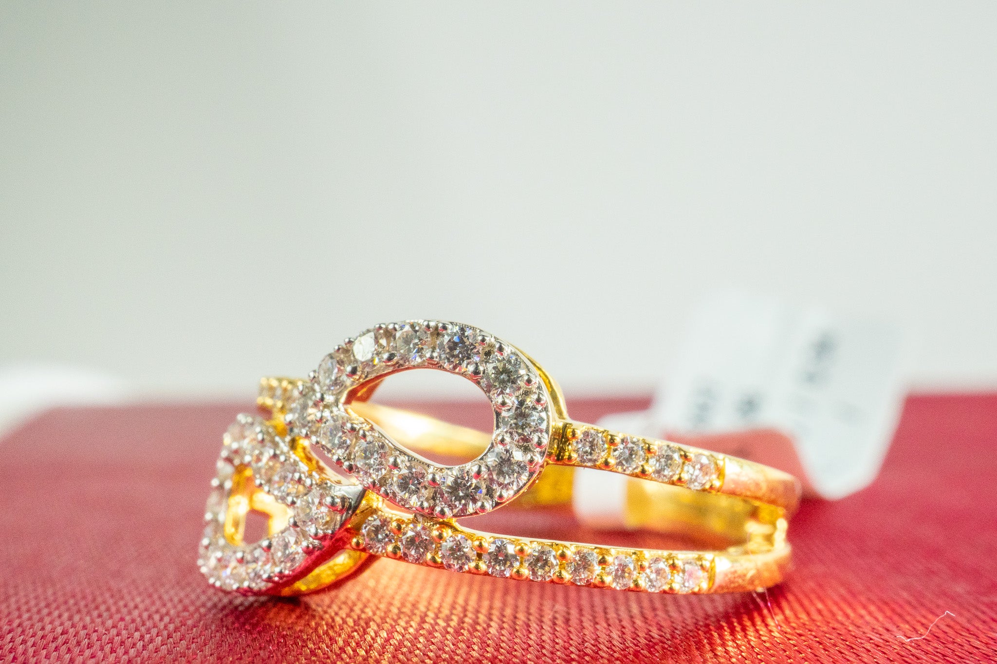 18K gold diamond infinity ring shown from an angled side view with pavé diamond details.