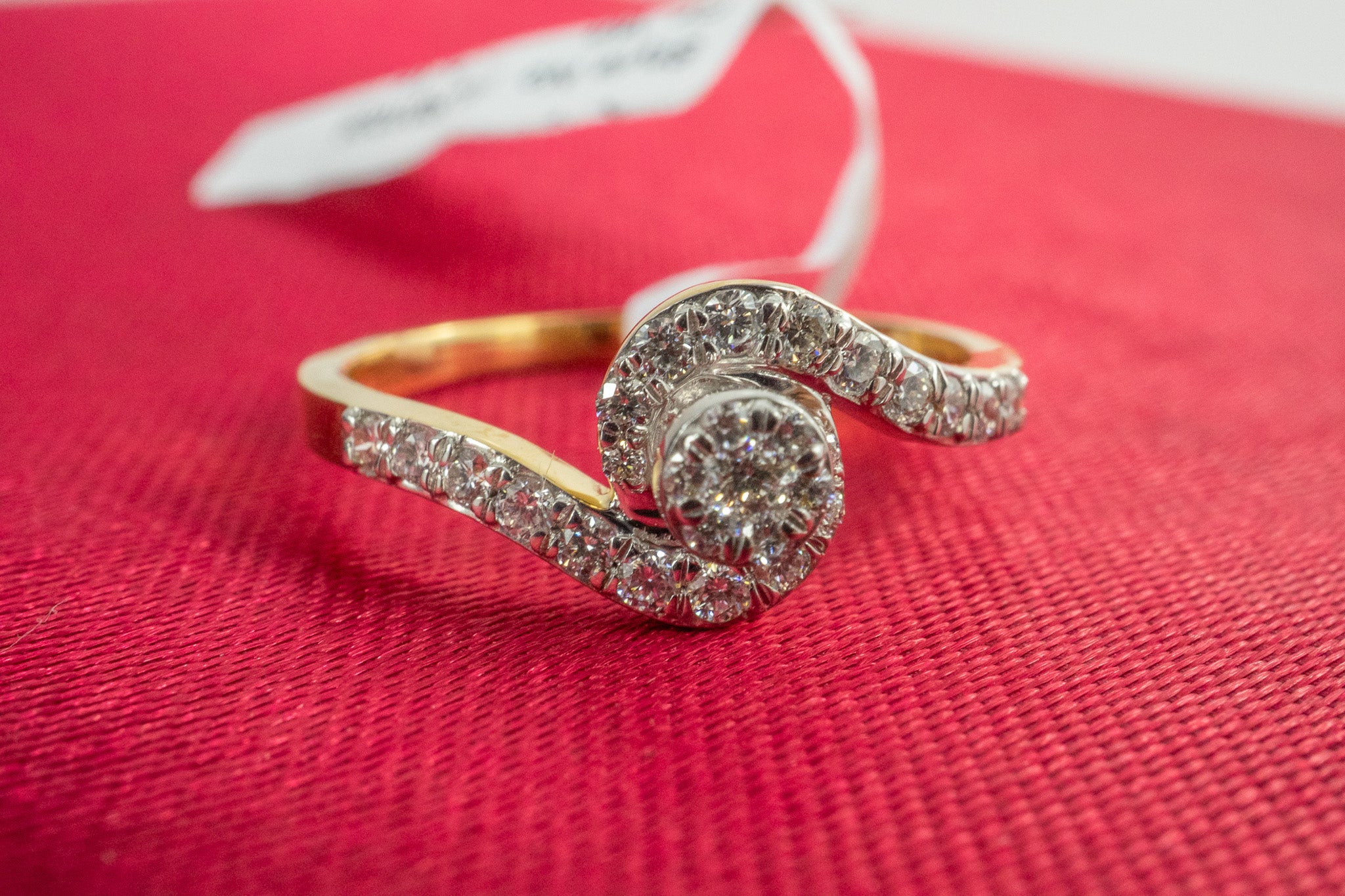 Angle view of the Glimmer Dot Ring, 18K gold diamond swirl bypass ring with pavé-set diamonds.