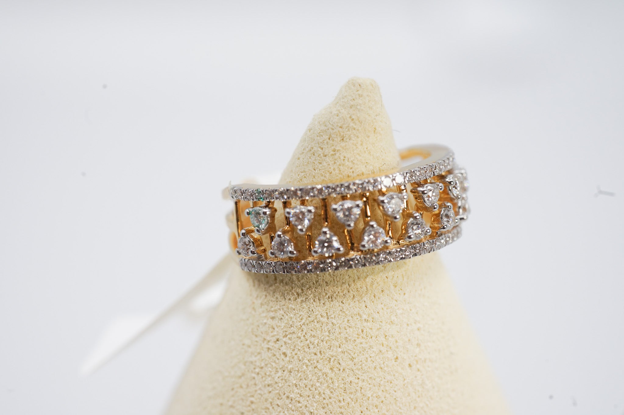 18K gold wide diamond band ring with 0.74 carat diamond weight on display stand.