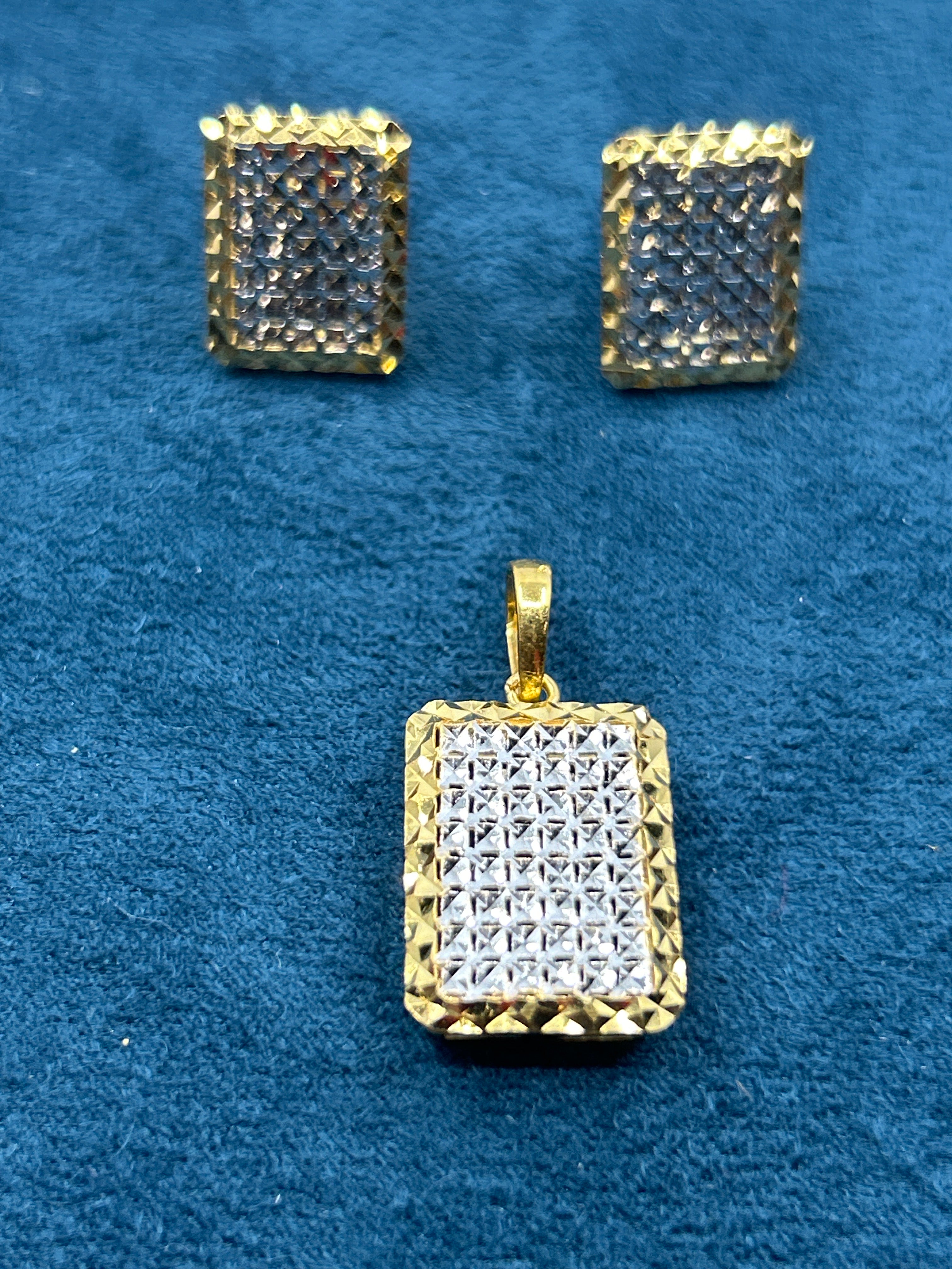 Two-tone square pendant with matching square stud earrings on a blue background